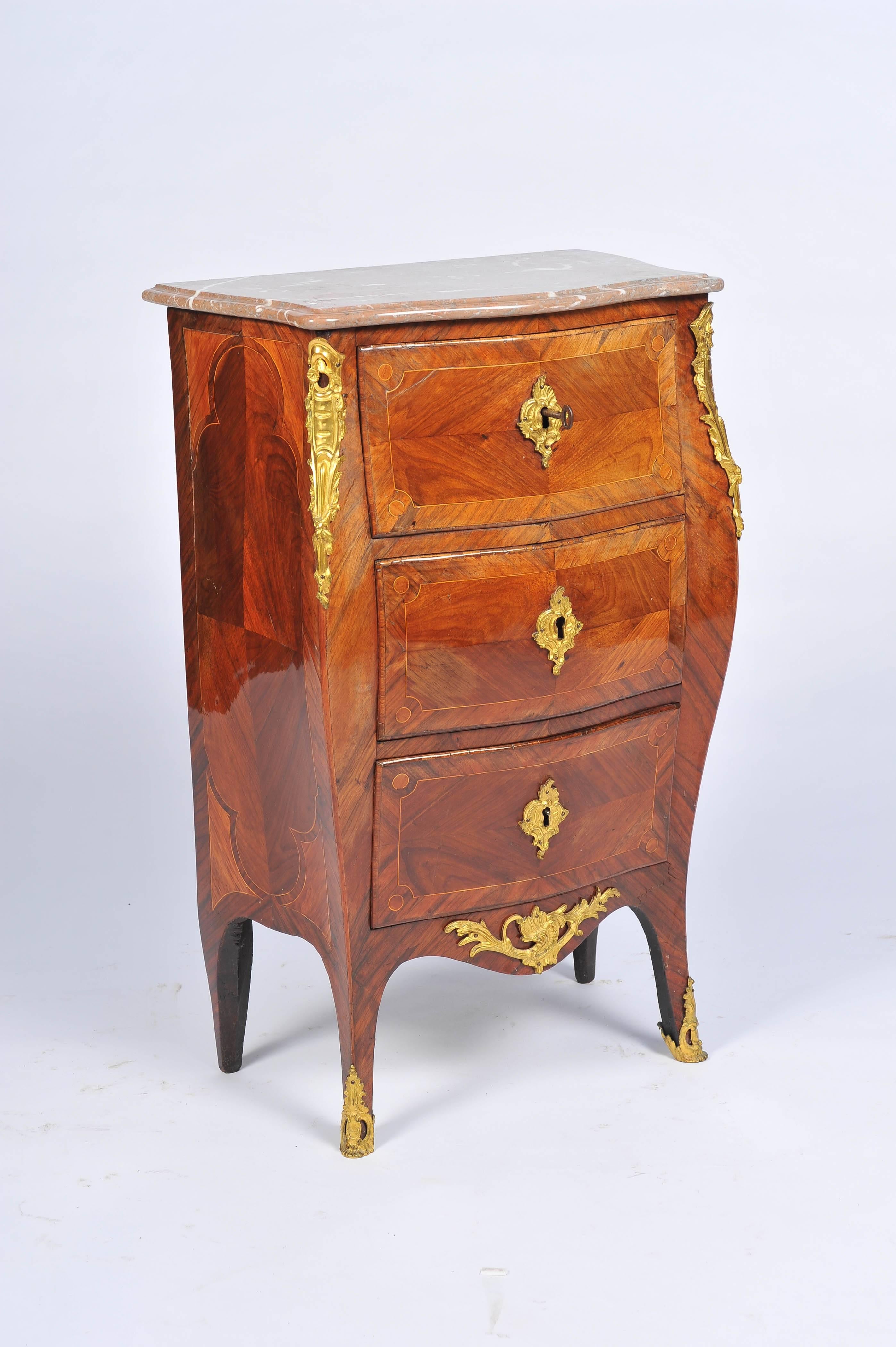 A good quality 18th century Regence period bombe fronted commode. Marble topped, ormolu-mounted, the drawer fronts having quartered veneers and crossbanded, raised on out swept legs, terminating in ormolu feet.
Maker's name stamp under marble is
