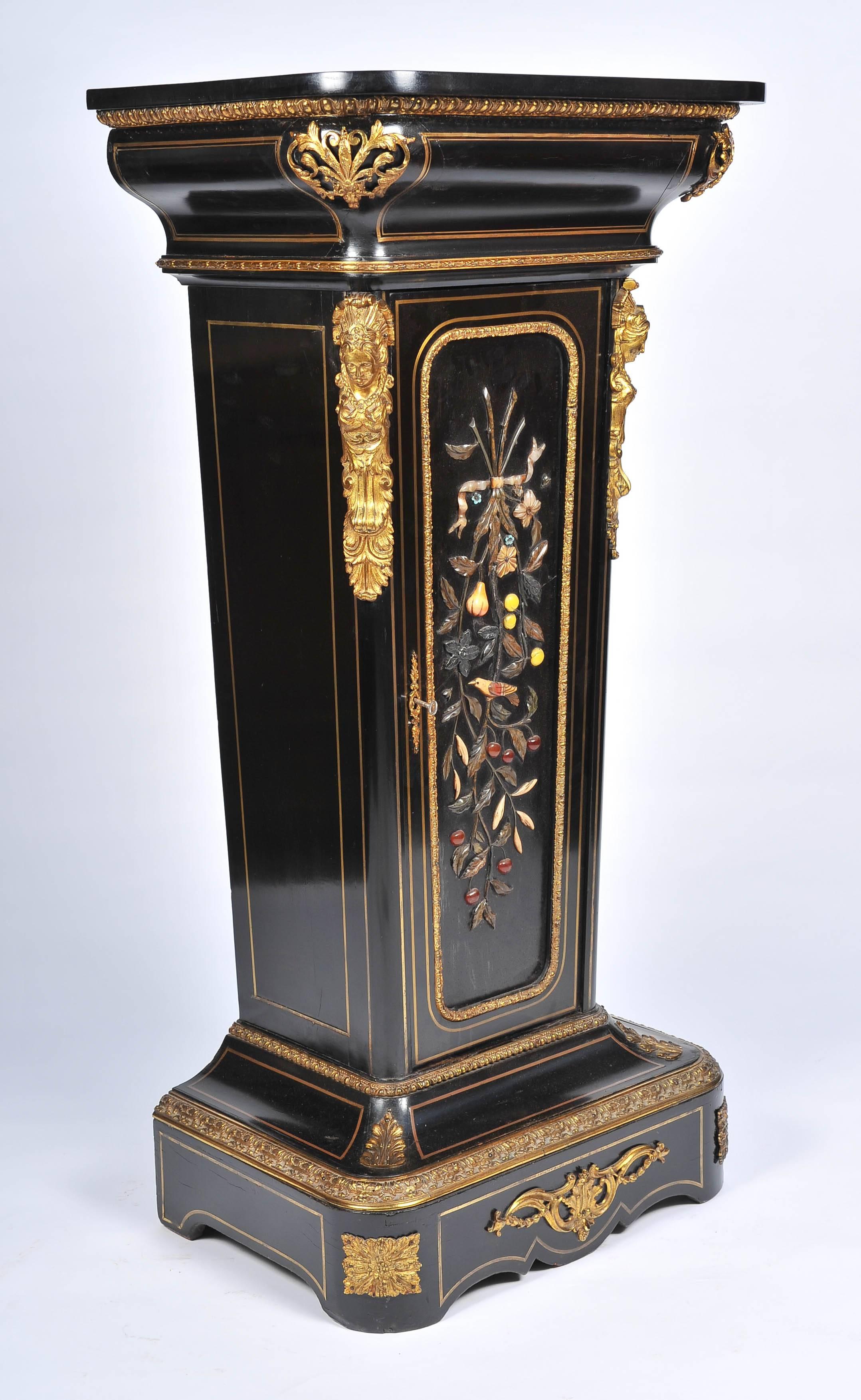 A very impressive 19th century French ebonized tapering pedestal. Having gilded ormolu mounts, brass inlay and a wonderful colored Pietra Dura inlaid panel to the hinged front door.