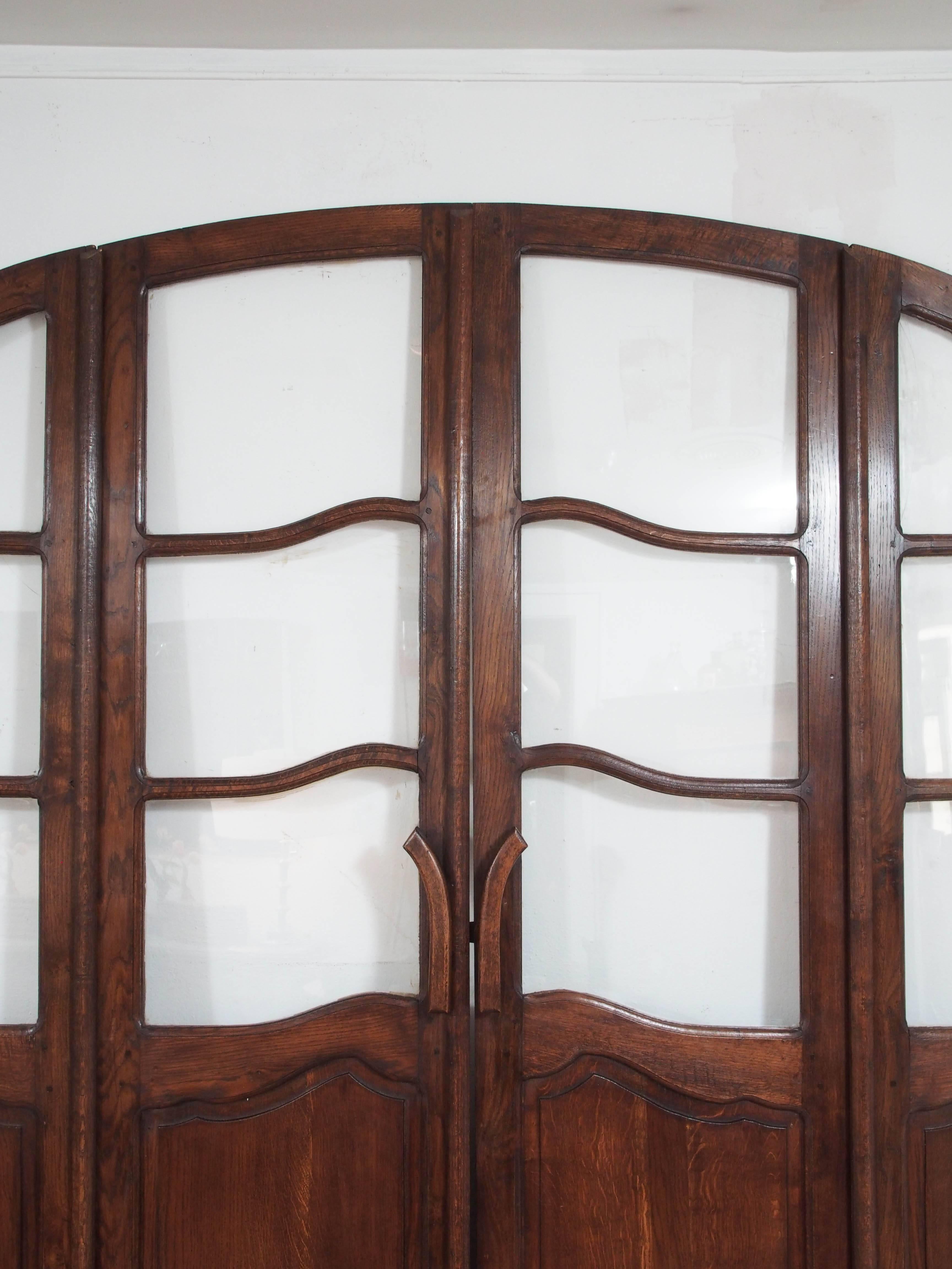 19th century carved French oak façade with two center folding doors containing 12 glass panes, circa 1880.