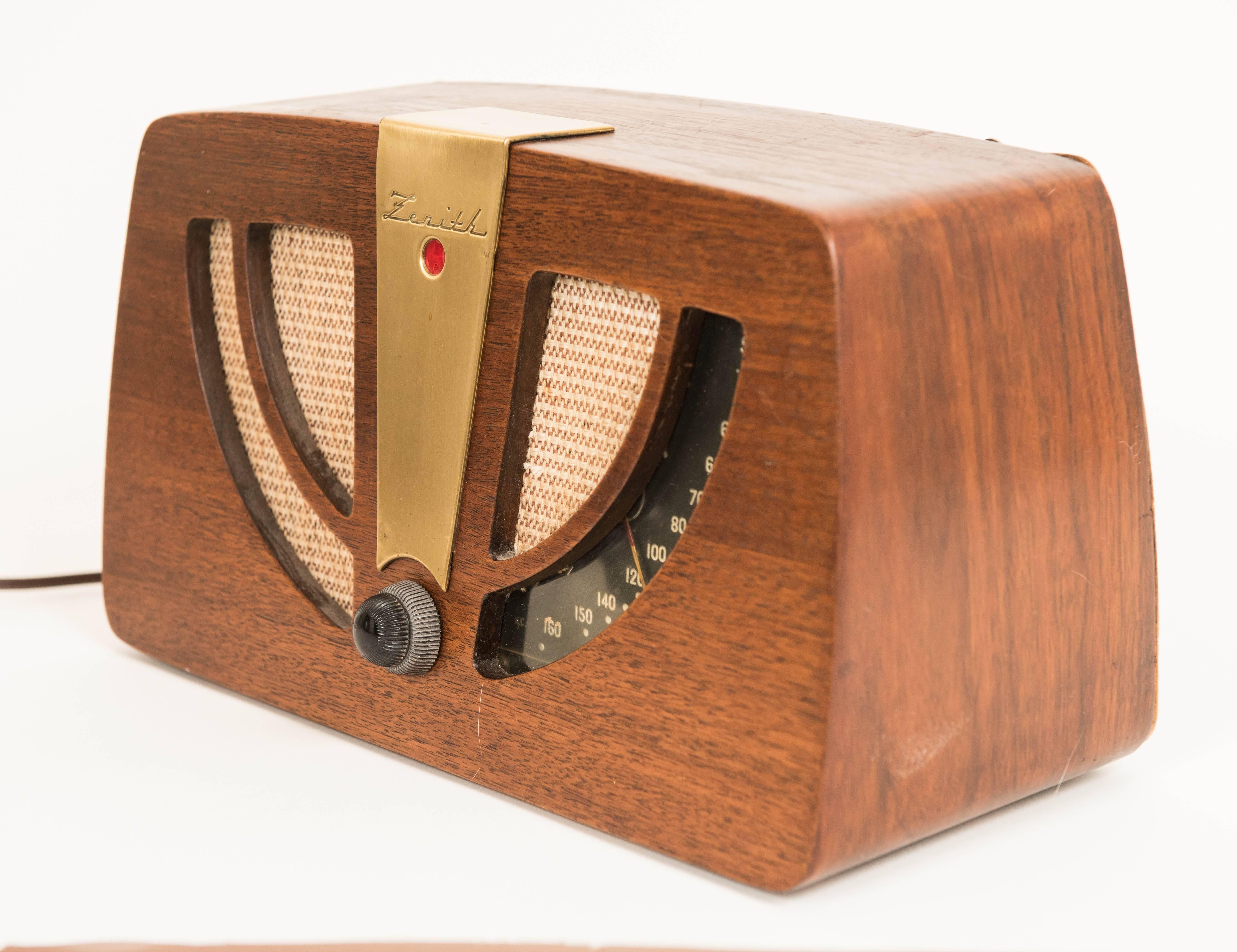 A walnut plywood, fabric, brass and Bakelite Zenith radio designed by Charles and Ray Eames 1946.
Manufacturer stamp to reverse.