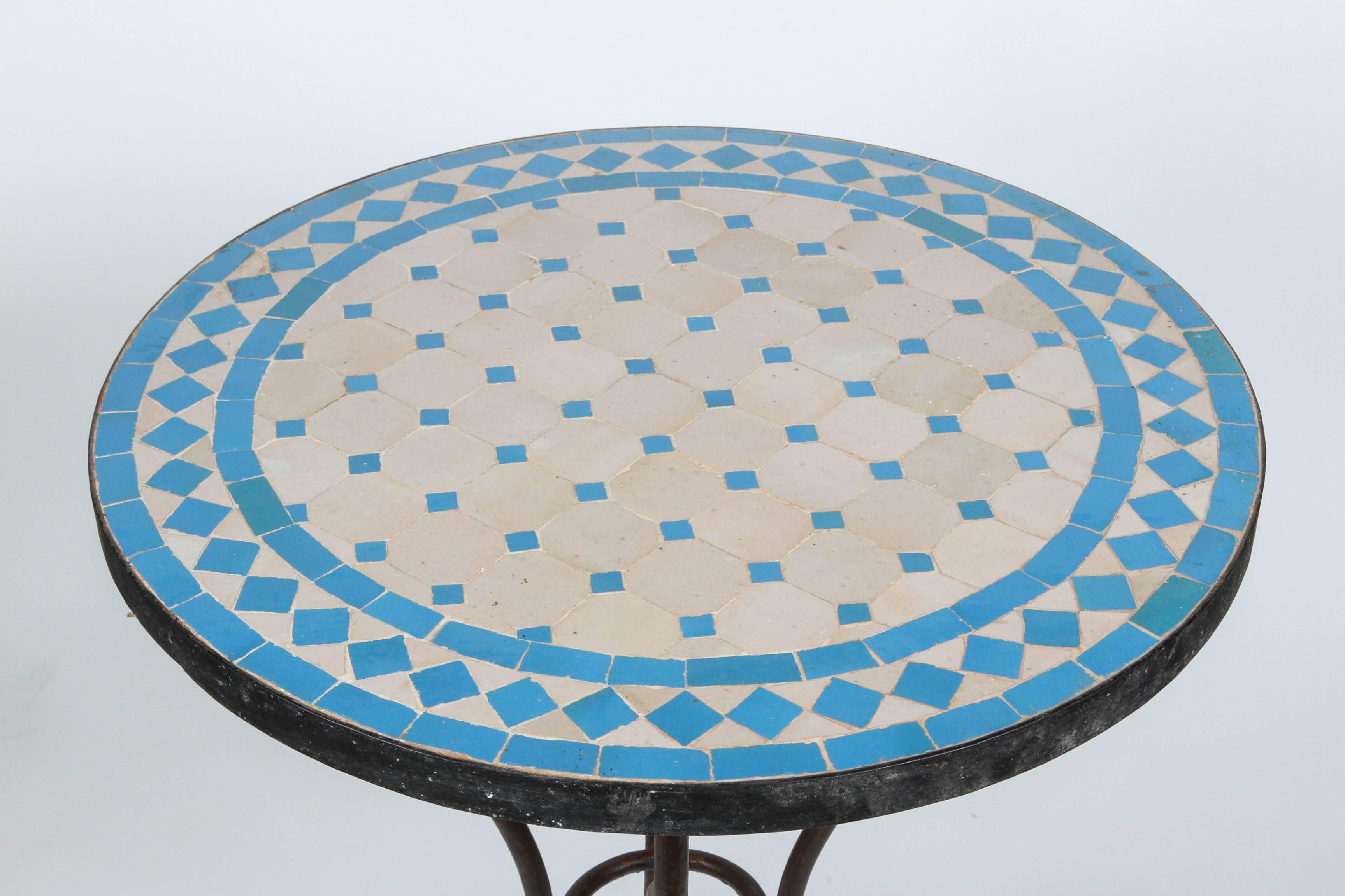 Moroccan mosaic tile  bistro table on iron base.
Handmade by expert artisans in Fez, Morocco using reclaimed old glazed tiles inlaid in concrete using reclaimed old glazed tiles and making beautiful geometrical designs, colors are turquoise blue and