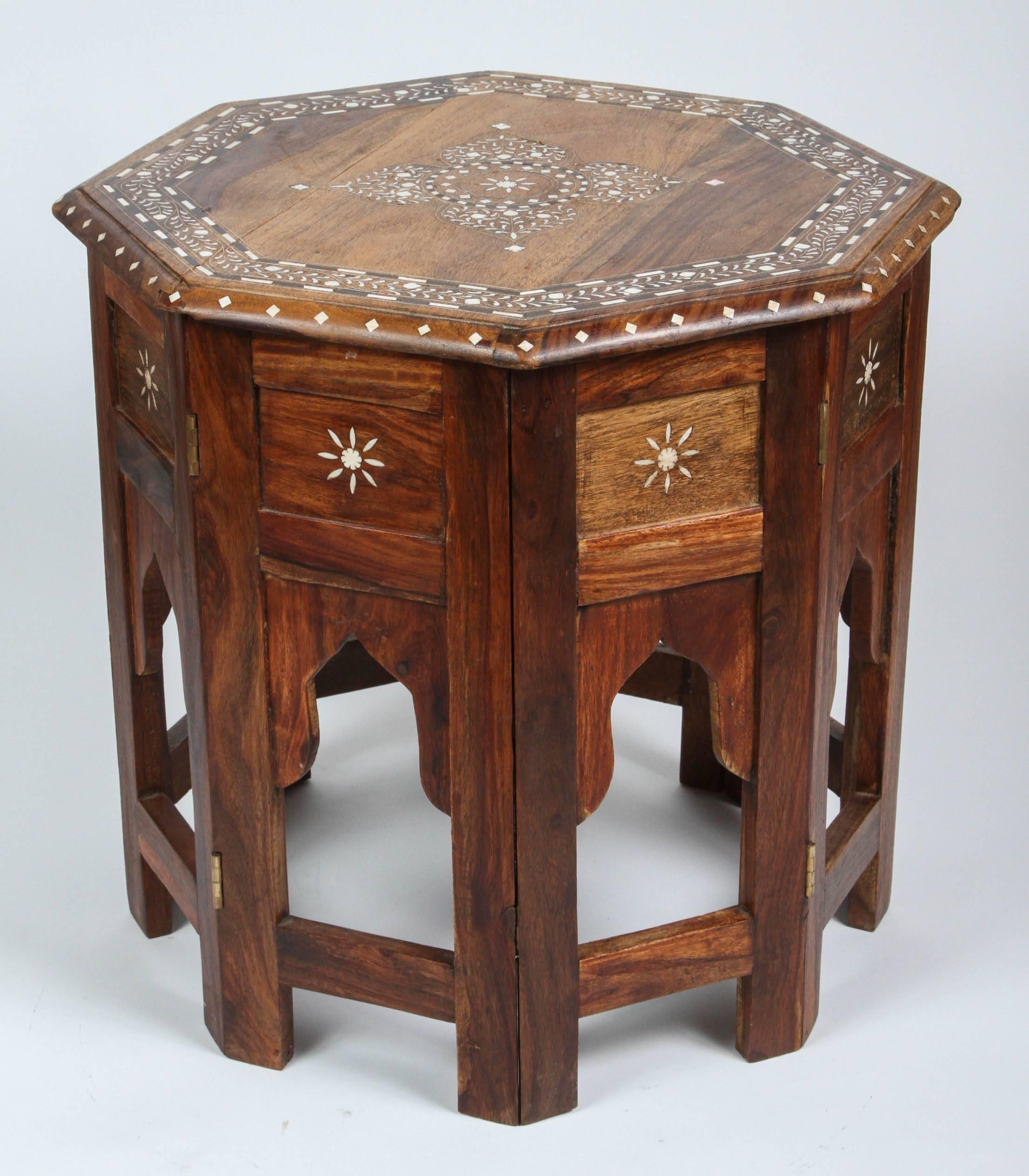 Anglo Indian folding wood bone Inlaid octagonal side Table.
Fine and elegant Moorish octagonal wood table with elaborate bone inlay.
The octagonal surface is finely carved and inlaid with bone details designs in the Mughal style..
The base has