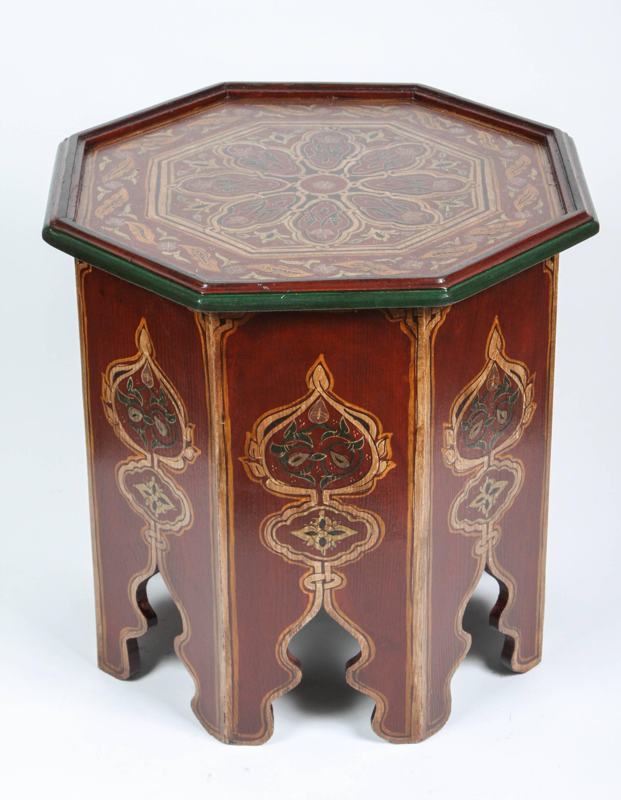 Pair of Moroccan hand-painted side tables with Moorish designs. Maroon background with multicolored floral and geometric designs. 
Very fine Moorish artwork on an octagonal shape base with hand cut Moorish arches on each sides.
You can use them as