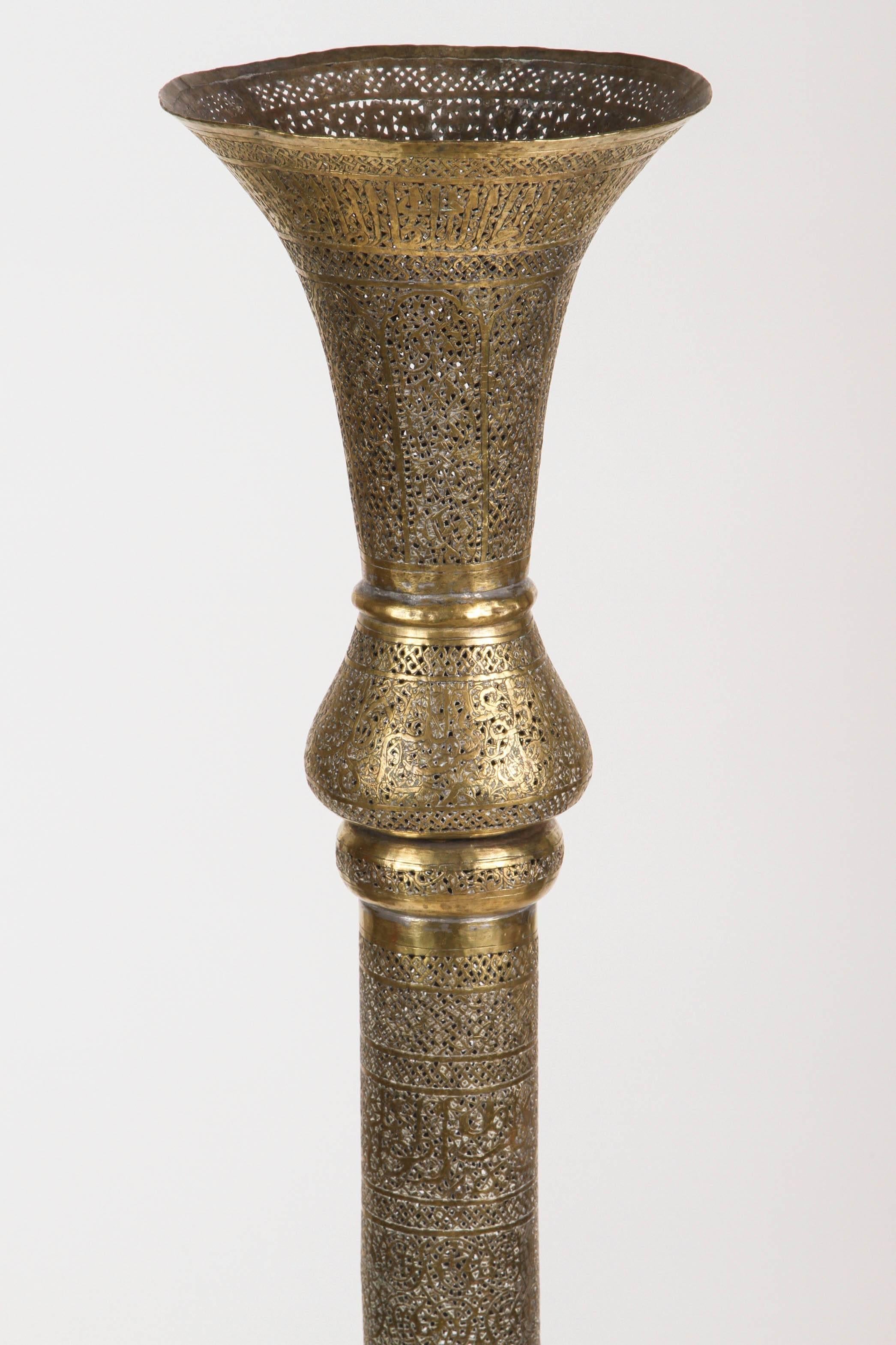 Extremely fine antique 19th Century Islamic floor candlestick in brass with Kufic Mamluke revival pierced foliate openworks chased and chiselled with Persian calligraphy.
Antique 19th century Middle Eastern Arabic candleholder.
46.5 inches Height x