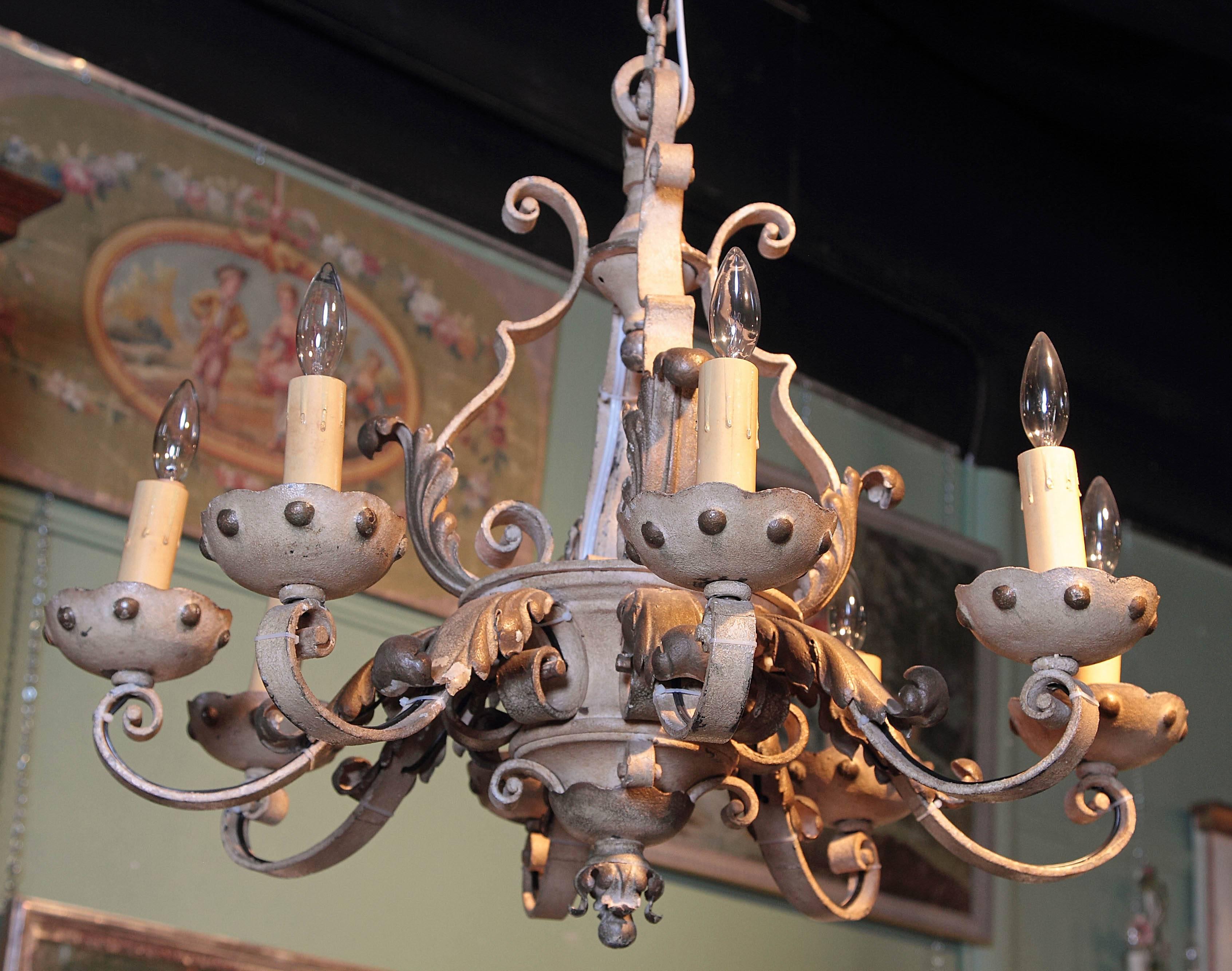 This heavy, round iron chandelier was crafted in France, circa 1890. The fixture has eight lights which have been rewired for easy use. The scrolling frame of the chandelier has its original grey, beige finish which is embellished with beautiful