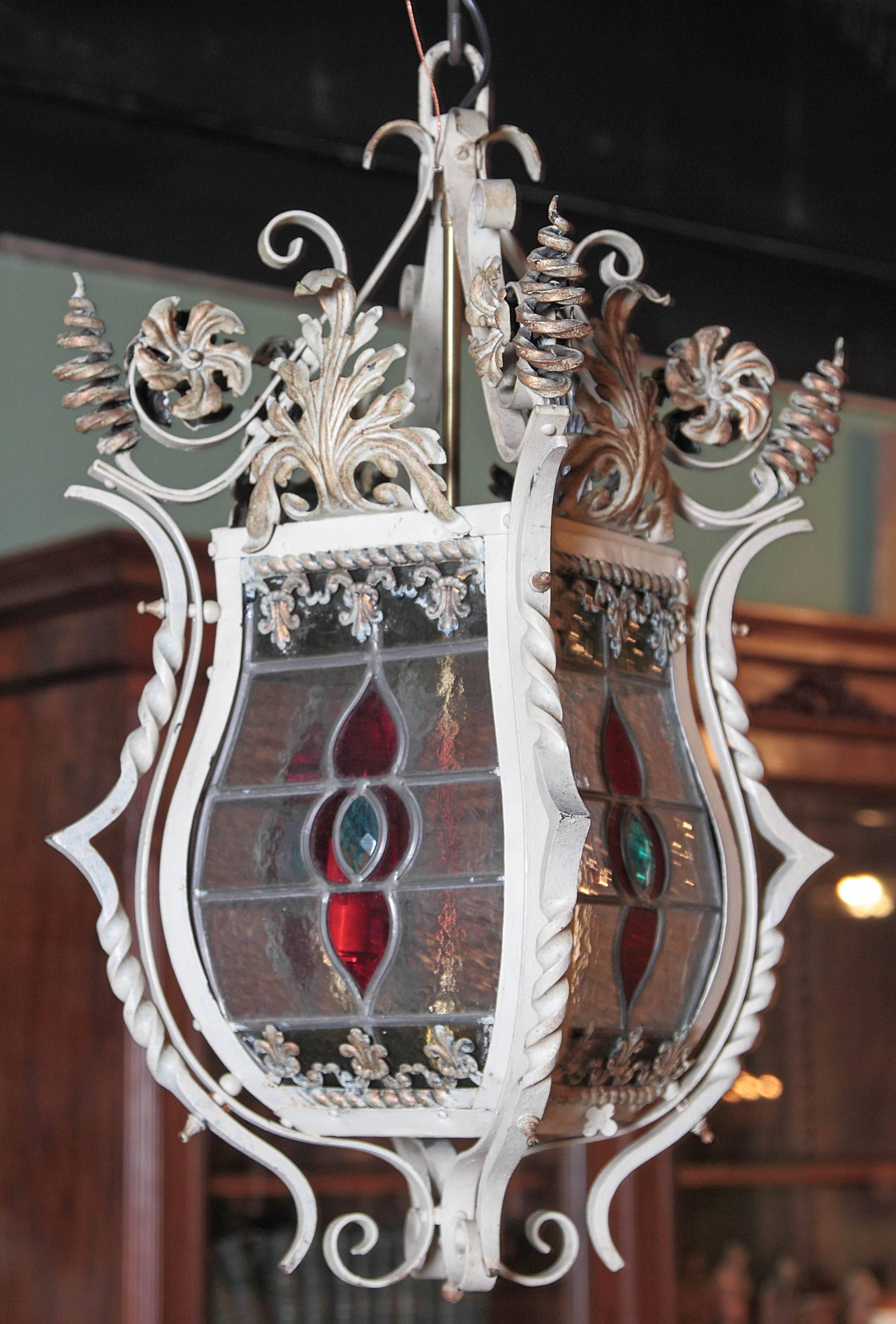 For a unique lighting feature, look no further than this beautiful, antique lantern from France, circa 1870. The French chandelier features four painted, stained glass panels embellished with fleurs de Lys. The frame of the lantern has its original,