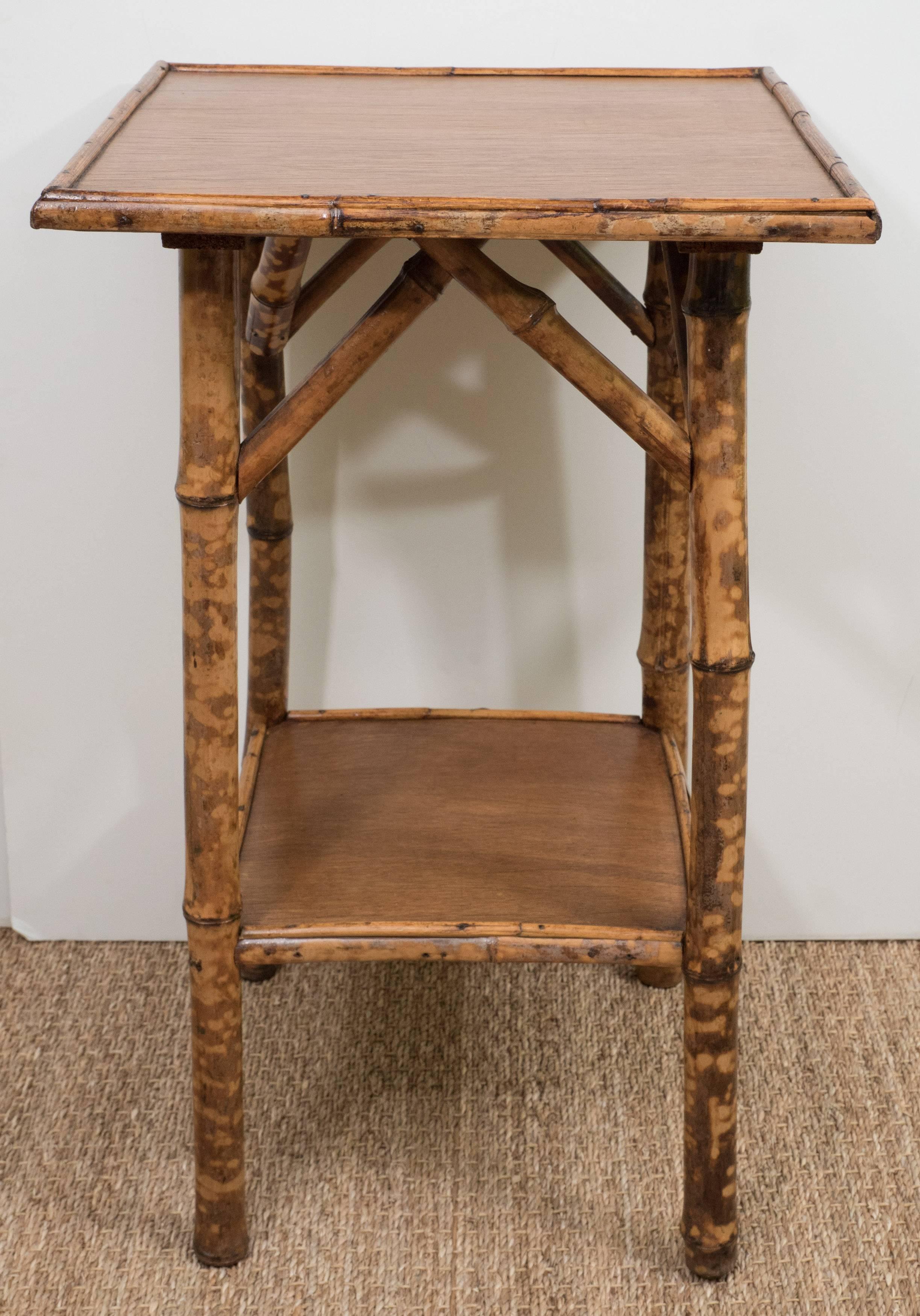 A charming square English bamboo side table with a lower shelf.