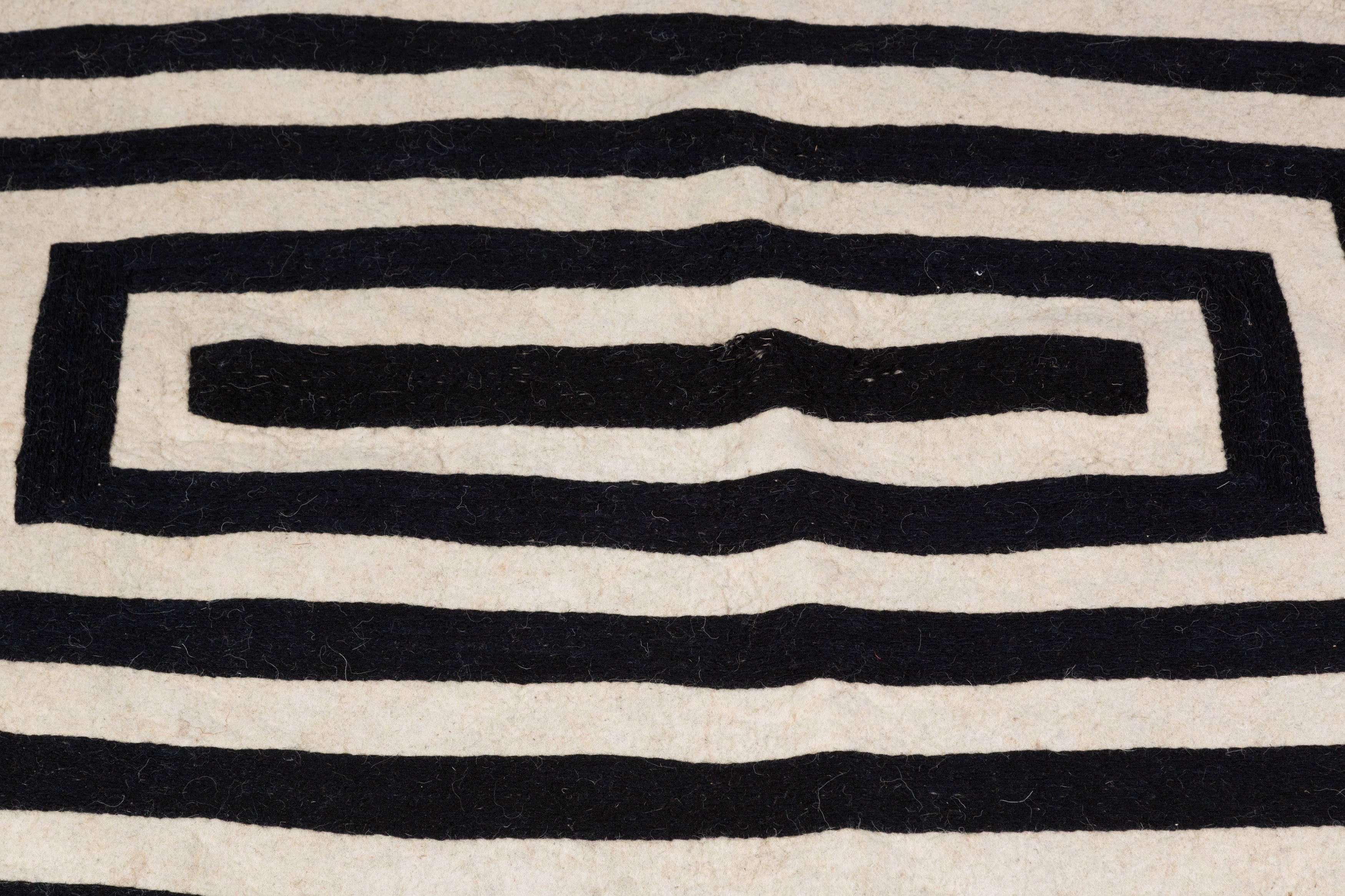 Contemporary Swedish black and white wool rug with natural fringe.