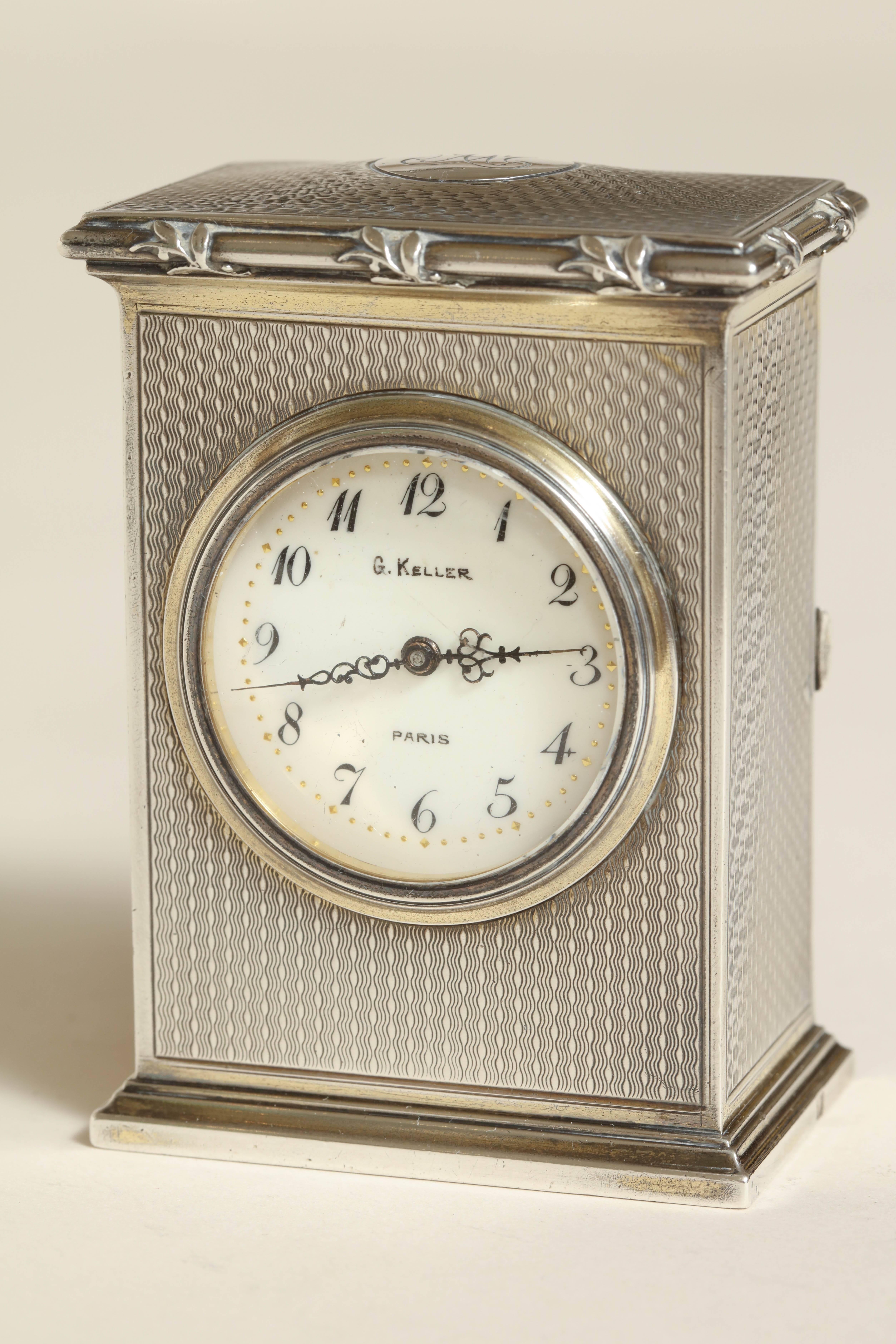 Measures: 3'' high, 2 ¼'' wide, 1 ½'' long.
10.45 ozs. gross.

Small silver gilt clock with door in rear which opens to wind-up mechanism. Fancy monogram on top.
Impressed with Minerve for 950 silver/ G KELLER/ PARIS/ Keller poincon GK head of