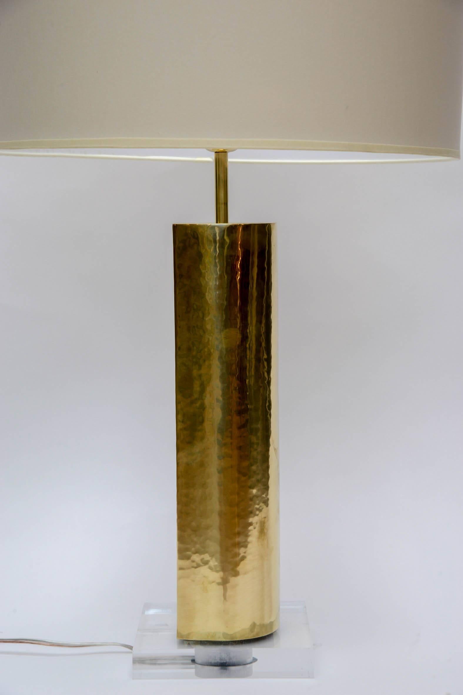 Elegant pair of lamps made of plexiglass feet and hammered brass body.

Shaped as a square, one angle is rounded giving the lamps a different shape depending how you look at it and also change the light's reflexion.