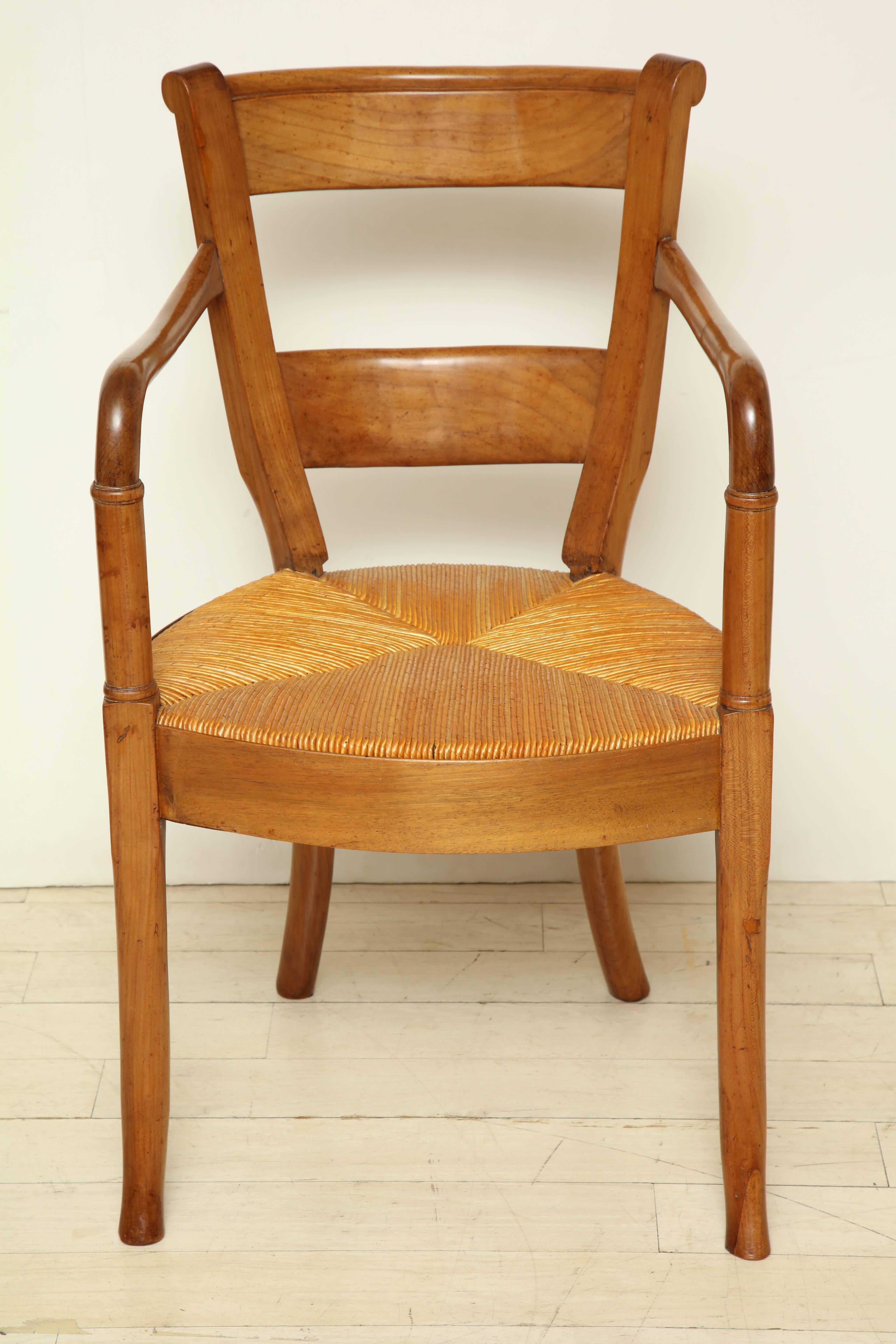 Provincial style blond walnut chair with curved arms and rush seat, France, circa 1880.