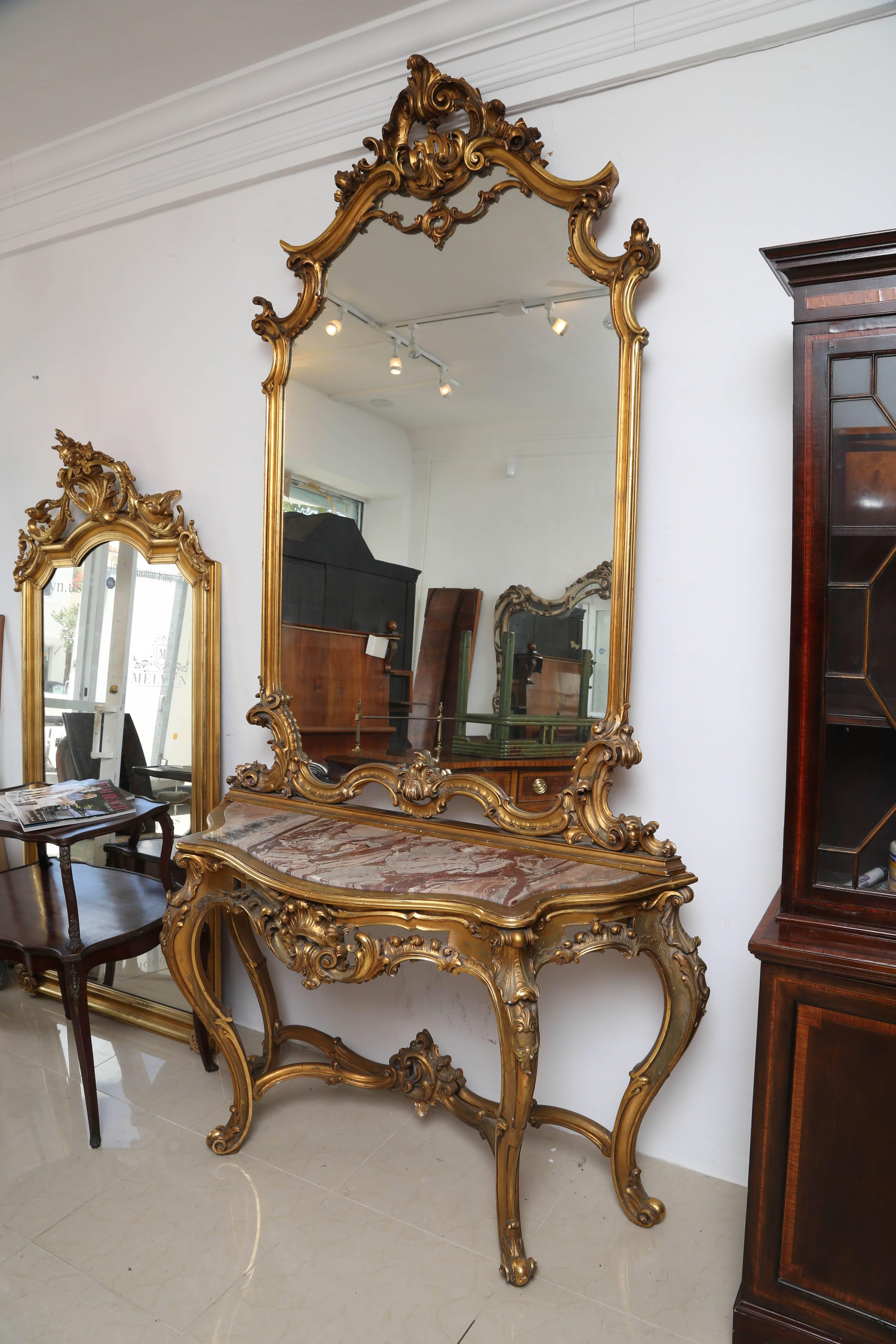 Superb gilt console table with marble top and mirror, it sits on large French style carved cabriolet legs.
This comes in two parts, it could be used as two separate items.
The gilding is all original and in good condition, superb carving all-over