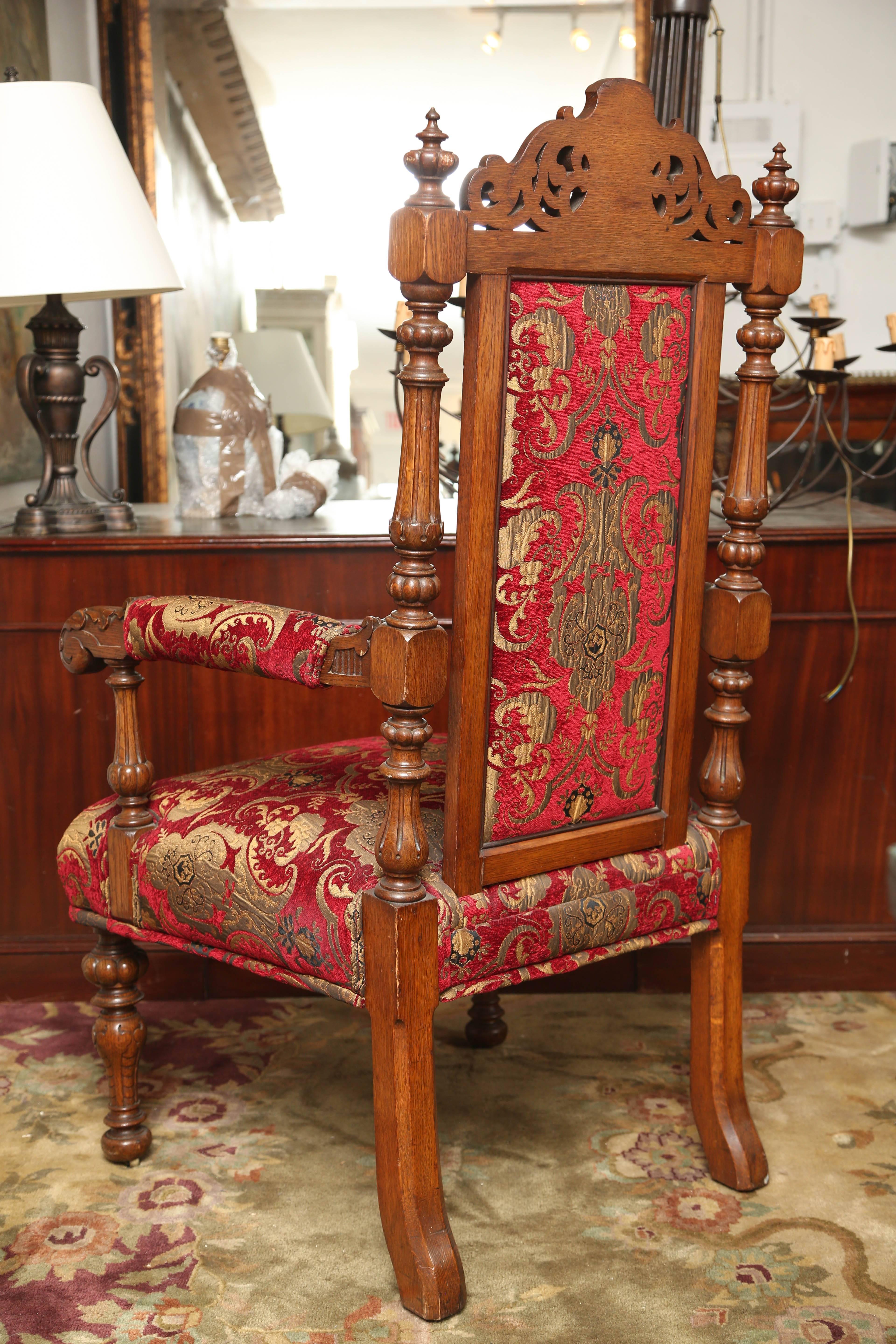 These are a very nice impressive pair of carved oak armchairs in a light color.
They sit on turned legs with carved arms and a carved crest to the top.
The fabric is in good condition, and the chairs are very comfortable.
These were made in