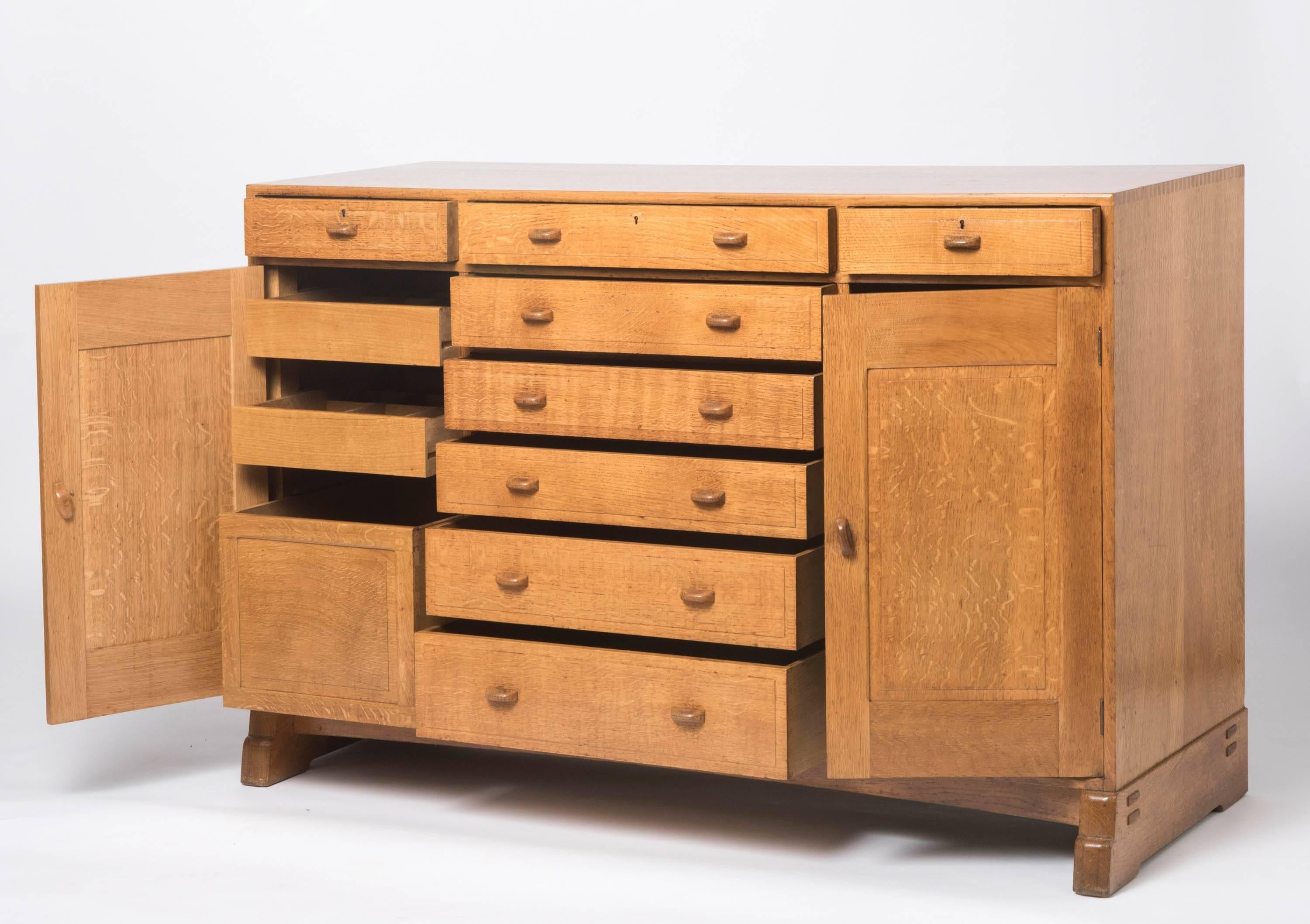 A superb oak sideboard attributed to Peter Waals (Dutch, 1870-1937).
The central six graduated drawers flanked by two further drawers and cupboards.
Exposed dovetails. Shaped handles.
On stepped supports with exposed joints.
England, circa
