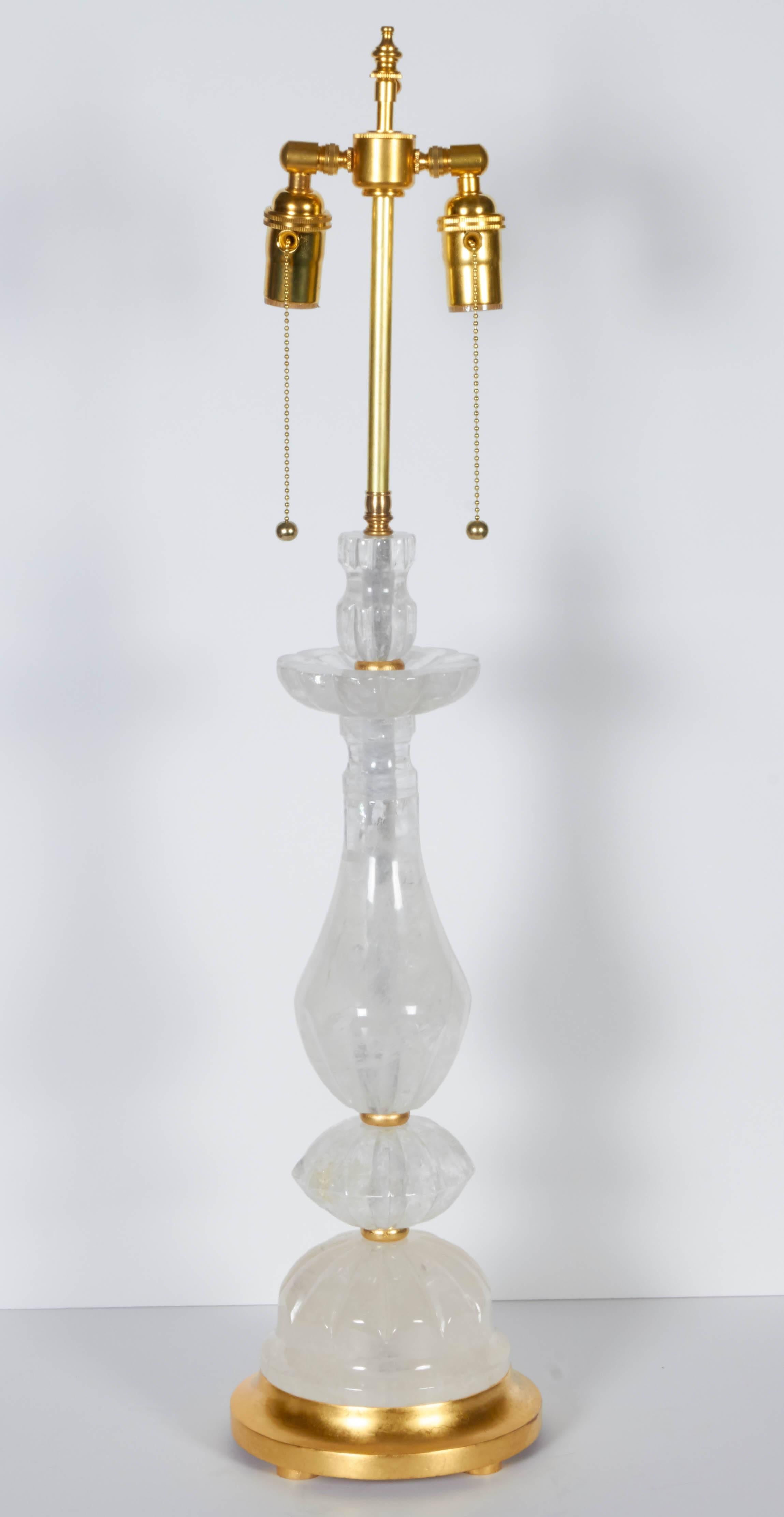 A pair of rock crystal table lamps, giltwood elements, double cluster fitting, wired for electricity.