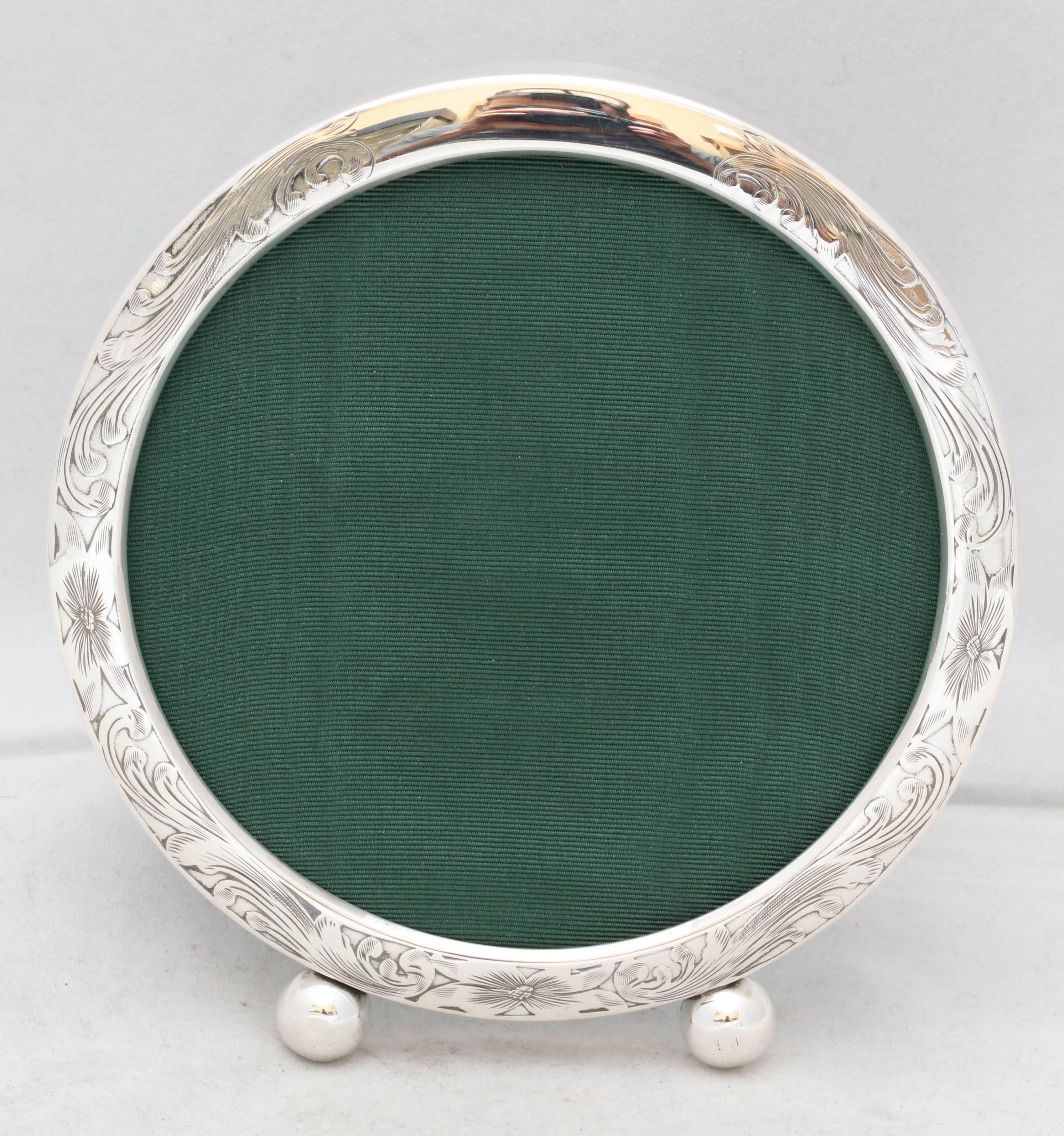 Edwardian, sterling silver round picture frame on ball feet, The Sterling Silver Manufacturing Company, Providence, Rhode Island, circa 1910. Lovely, etched design. Measure: 5 1/2 inches diameter x 6 inches high; 4 inches deep when easel is in open