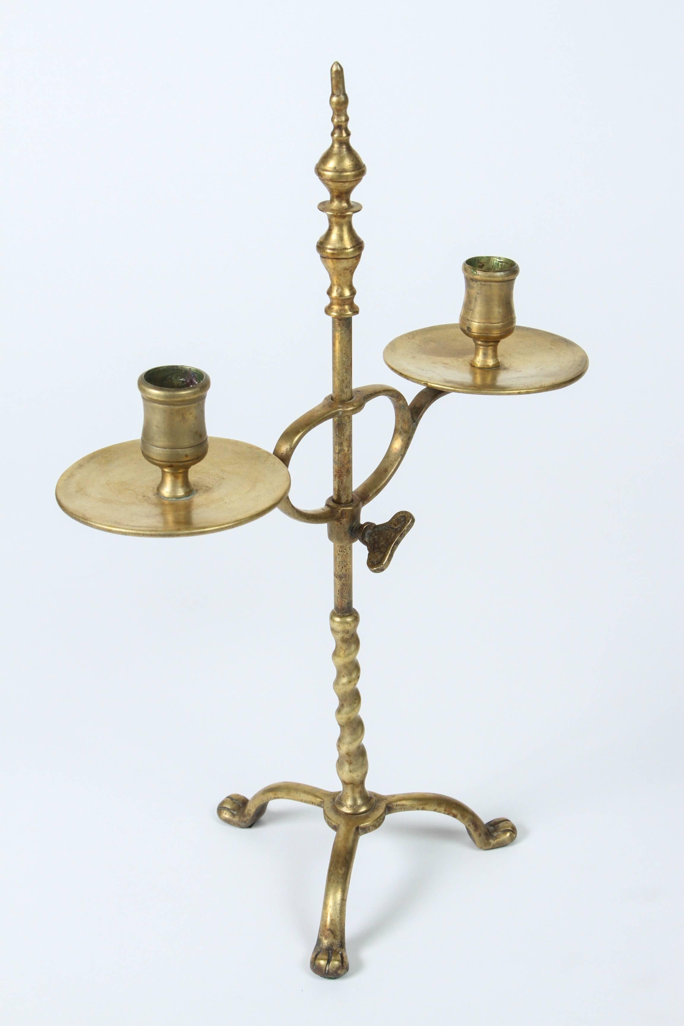 Vintage English brass two-arm candleholder with adjustable height.