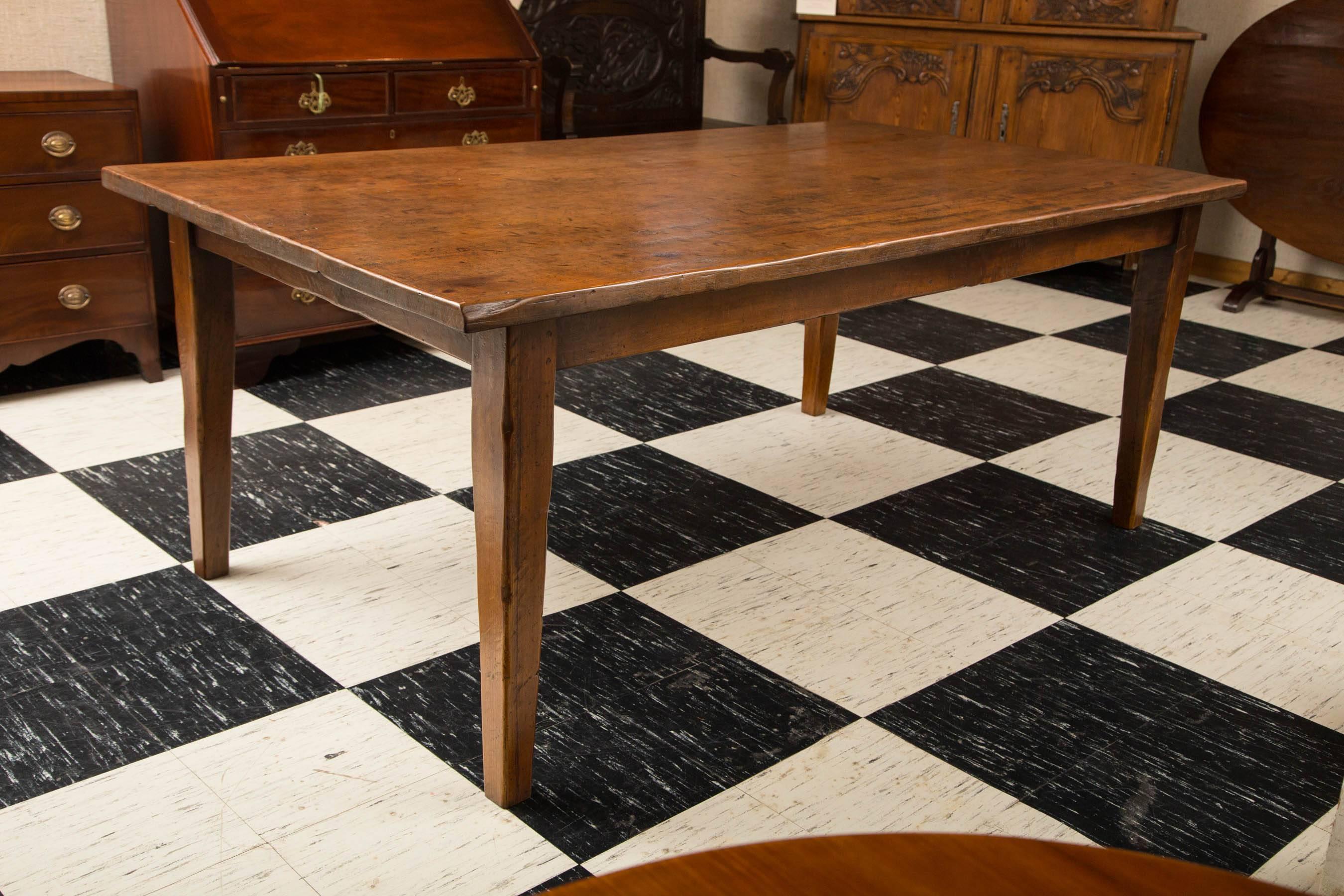 Three-plank antique French farm table with one-inch thick top resting on sturdy tapered legs. A table that has passed the test of time.