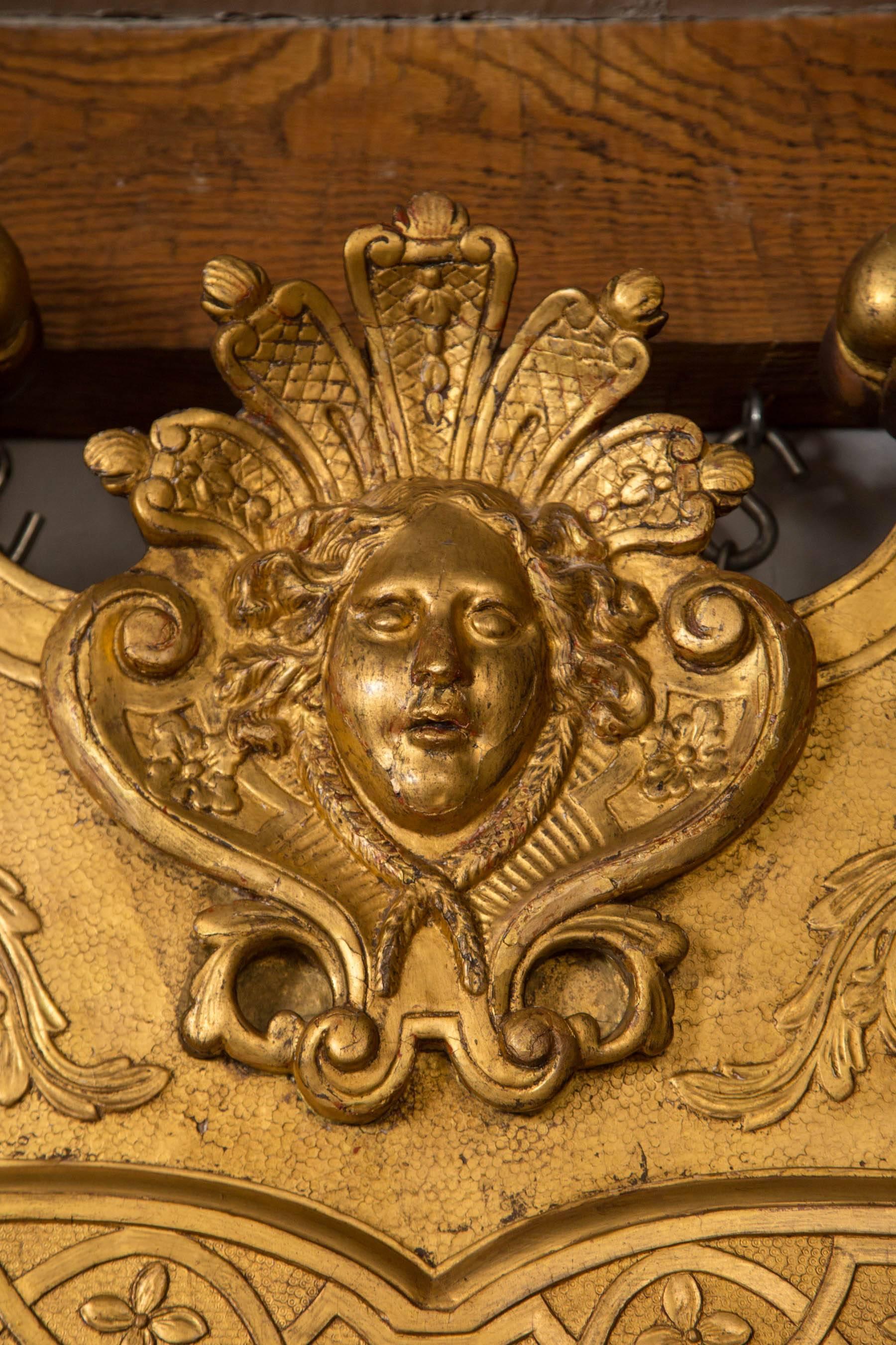 George II Vergoldung und Gesso Spiegel mit abgeschrägten zwei Glas Teile innerhalb eines Gitters und Blumenkopf verziert Grenze. Der Rahmen ist mit Blütenköpfen und Akanthusblättern verziert und wird von einer zentralen weiblichen Maske in einem