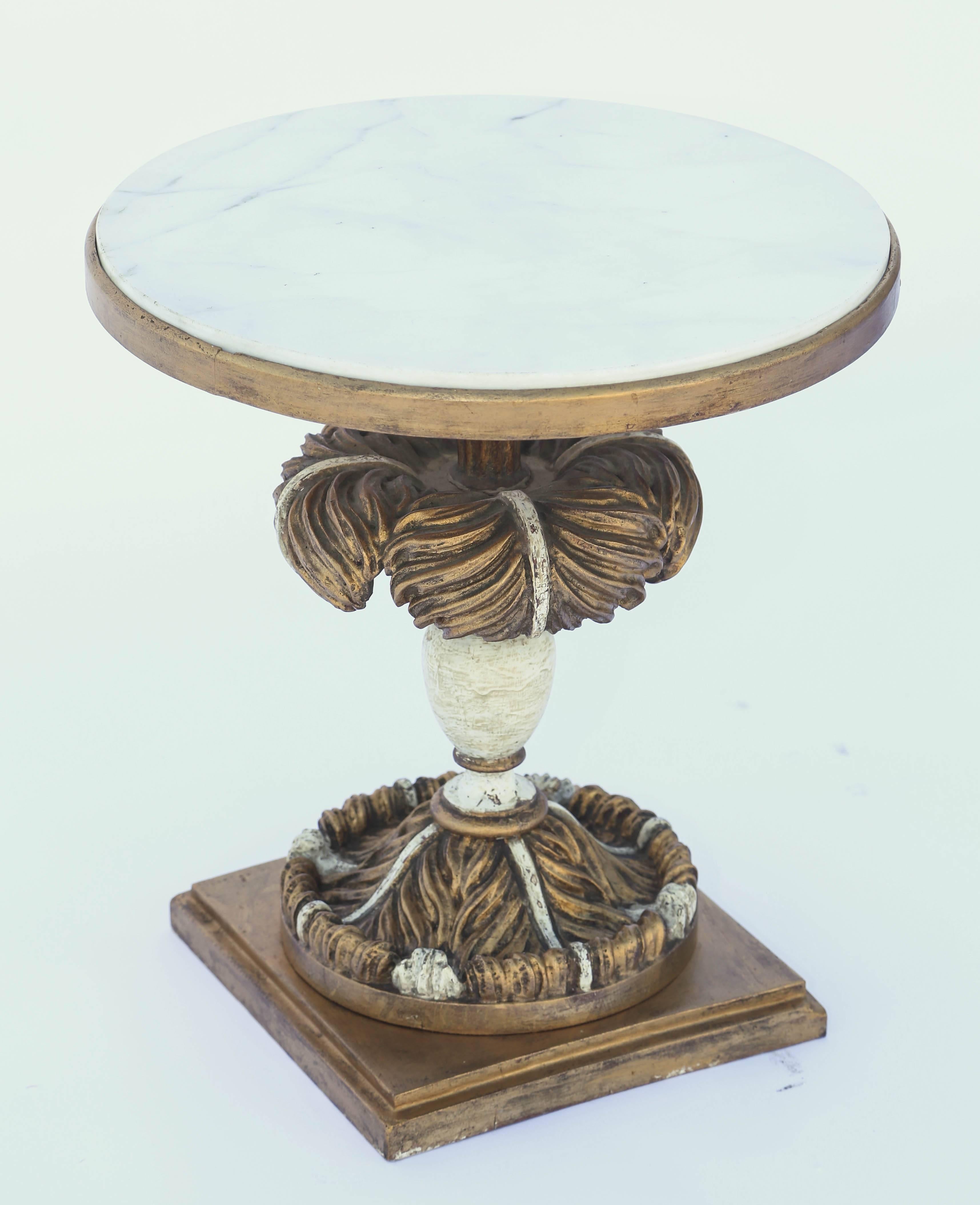 Side table, having a round top of Carrara marble, on painted and parcel-gilt pedestal base, of a hand-carved plume into a balustrade, on similar carved foot, set upon a graduating square plinth.

Stock ID: D8471