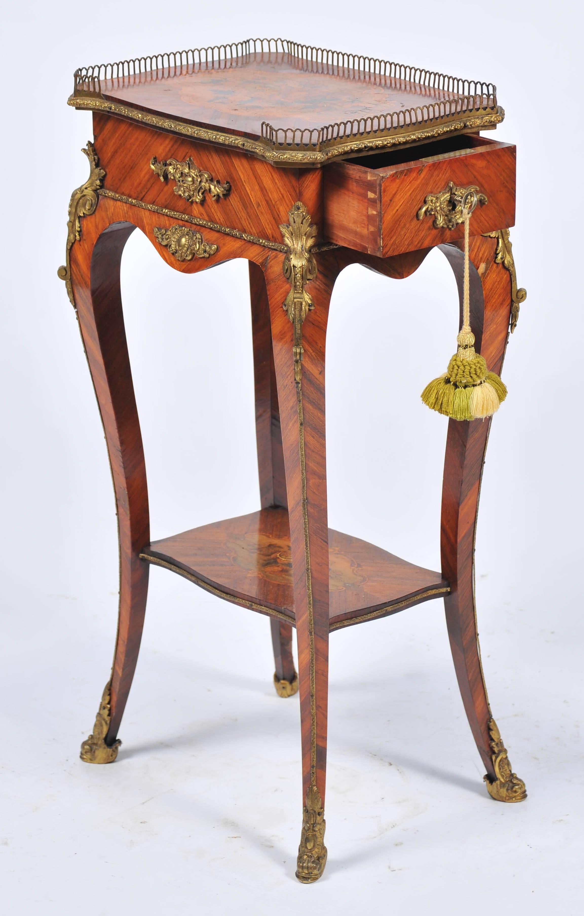 A good quality 19th century French Louis XVI style Kingwood marquetry inlaid side table. Having a brass gallery to the top, floral inlaid decoration to the top and under tier. A single frieze drawer, raised on cabriole legs, with ormolu mounts.
