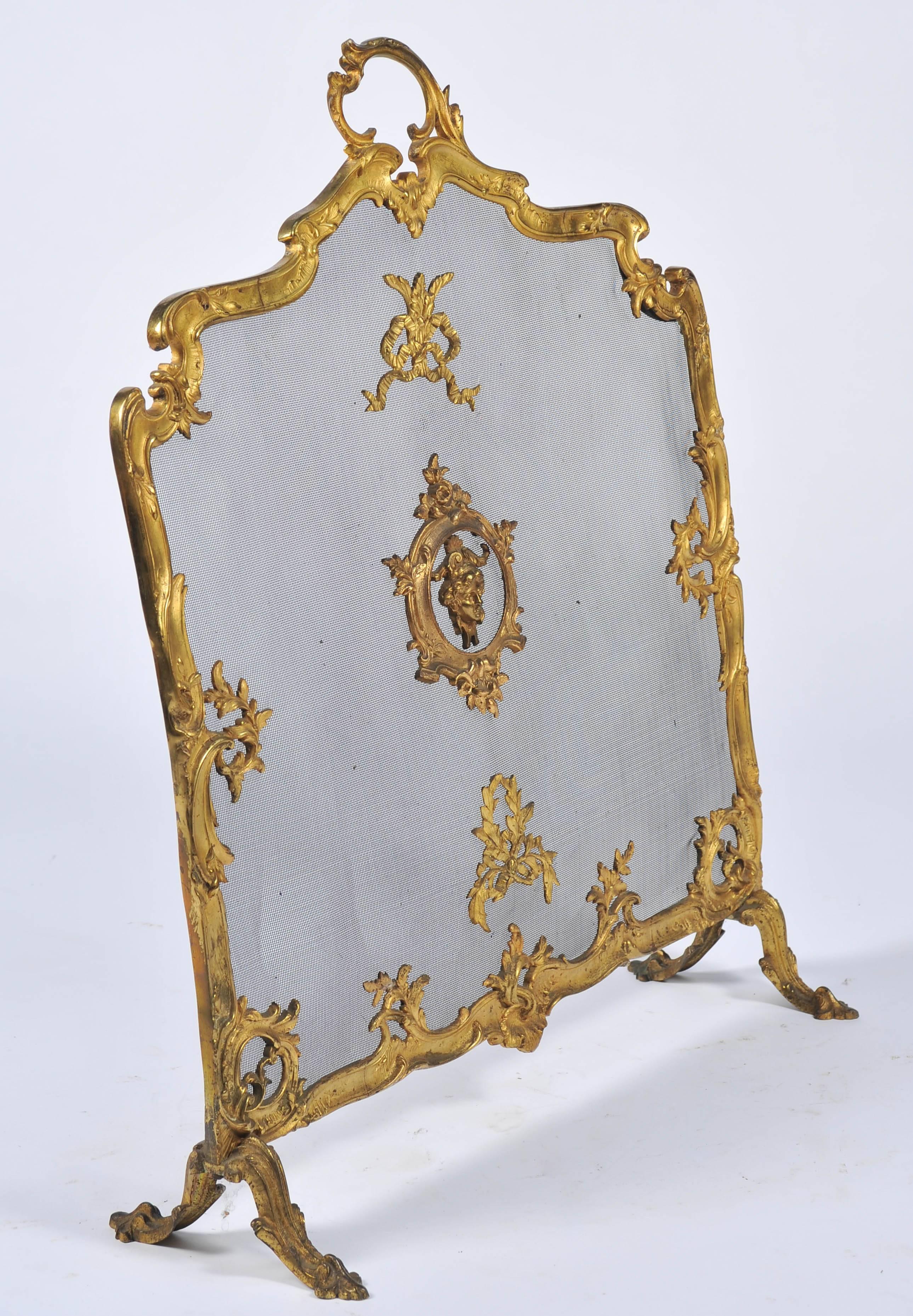 A good quality Louis XVI style brass fire screen, late 19th Century. Having scrolling foliate decoration, ribbons, swags and classical mask to the centre.