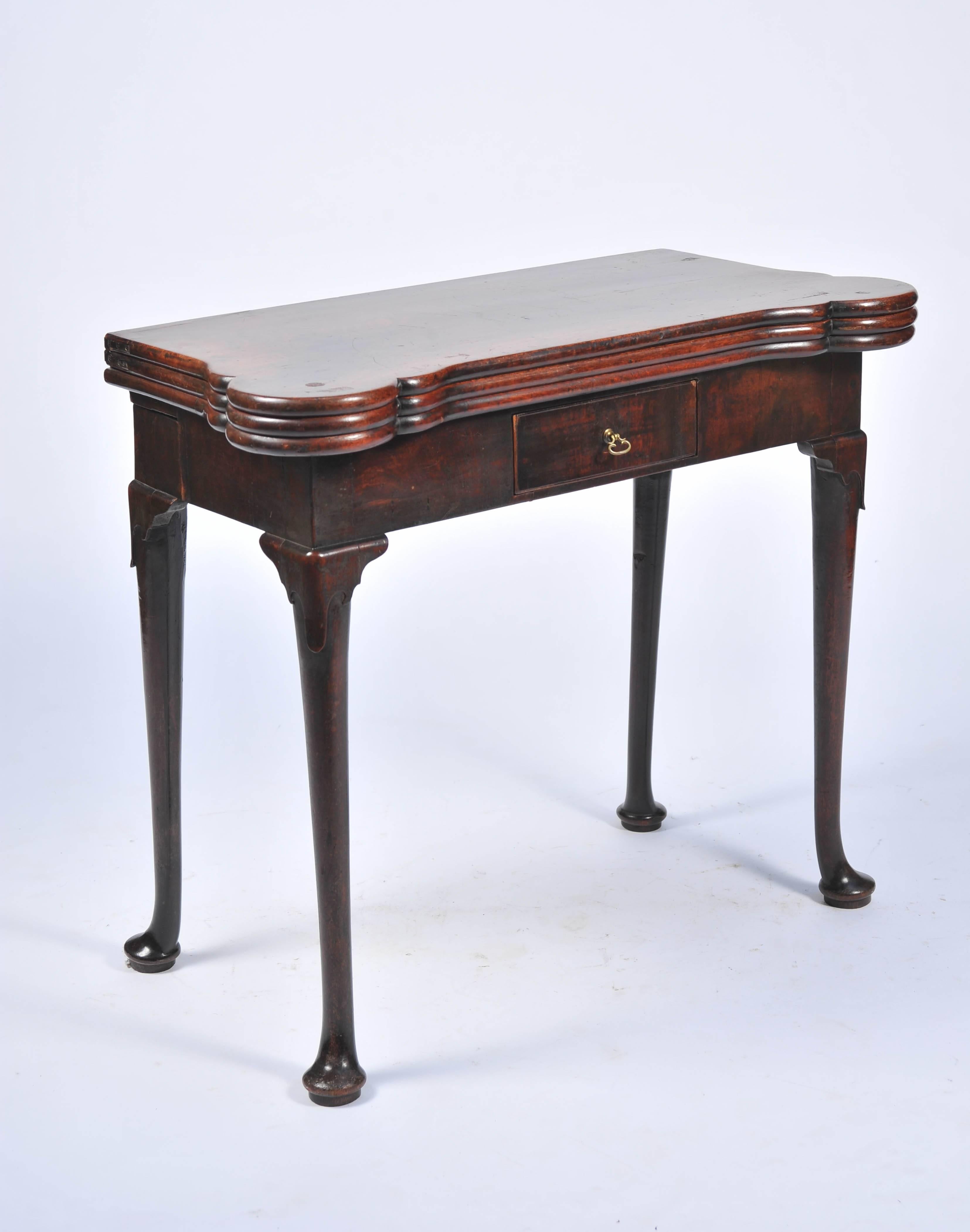 A rare triple layer George II mahogany card table, with a concertina action to the legs. The top unfolding to reveal a tea table with polished mahogany top, opening again to reveal a card table with carved recesses and a baize playing surface.