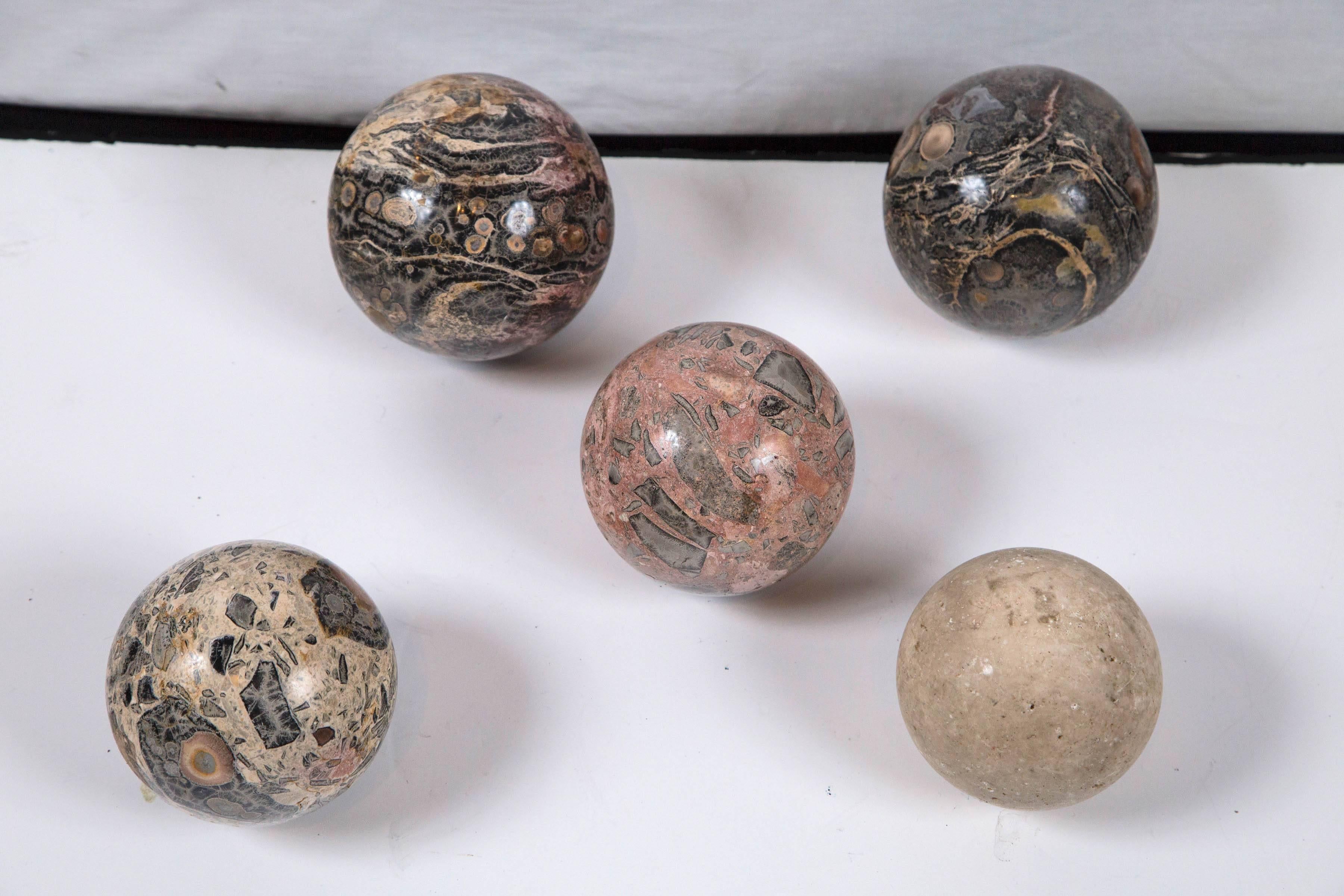Set of five polished marble spheres, Italy, circa 1950s. Each a different stone specimen. Sizes range from 4.5 inches to 5.5 inches. Display individually on stands or as group for a lovely decorative design accessory.