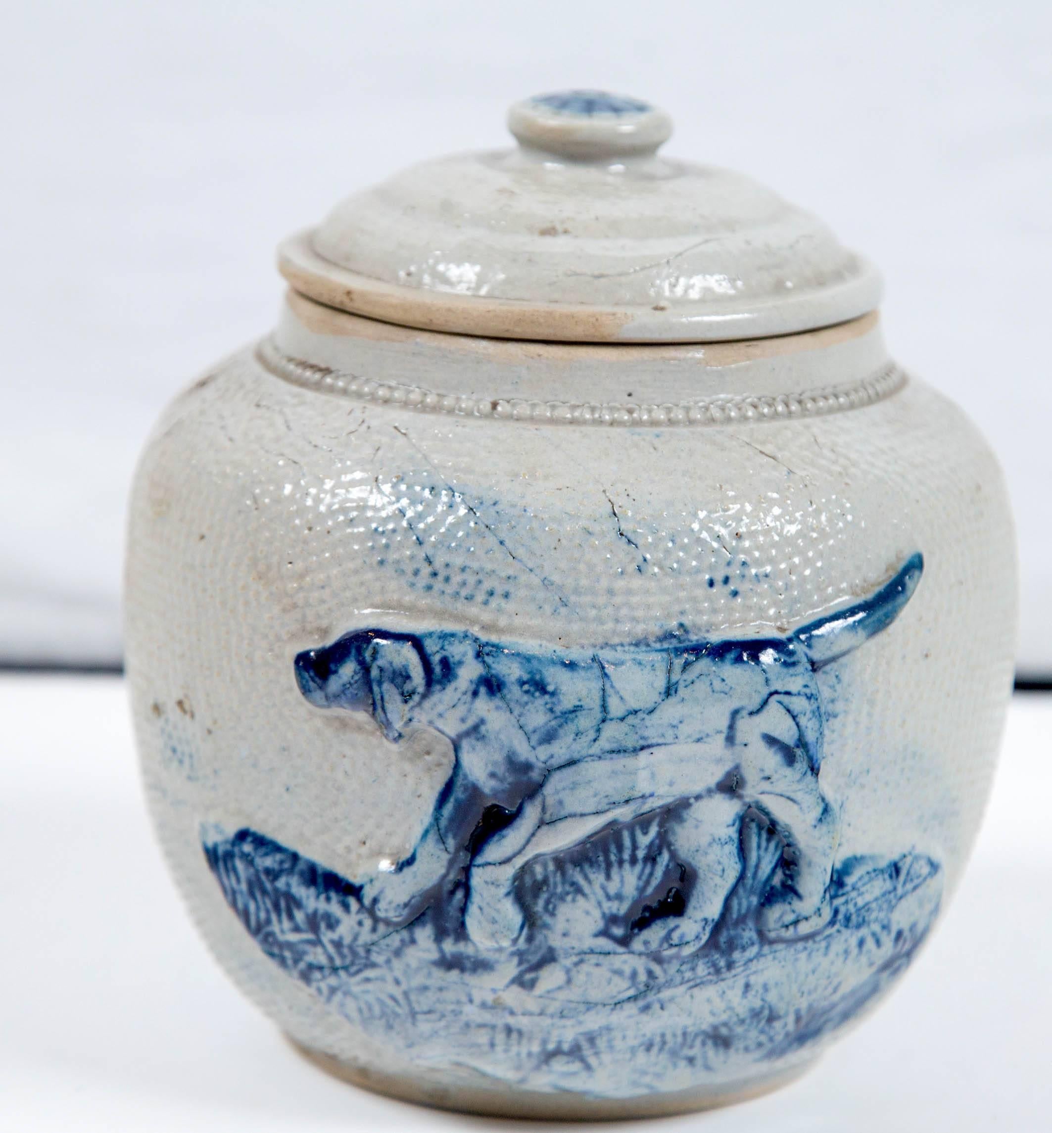 19th century blue glaze stoneware covered jar. Originally used as a humidor to store tobacco. Raised design in cobalt glaze depicting a hunting retriever dog.
