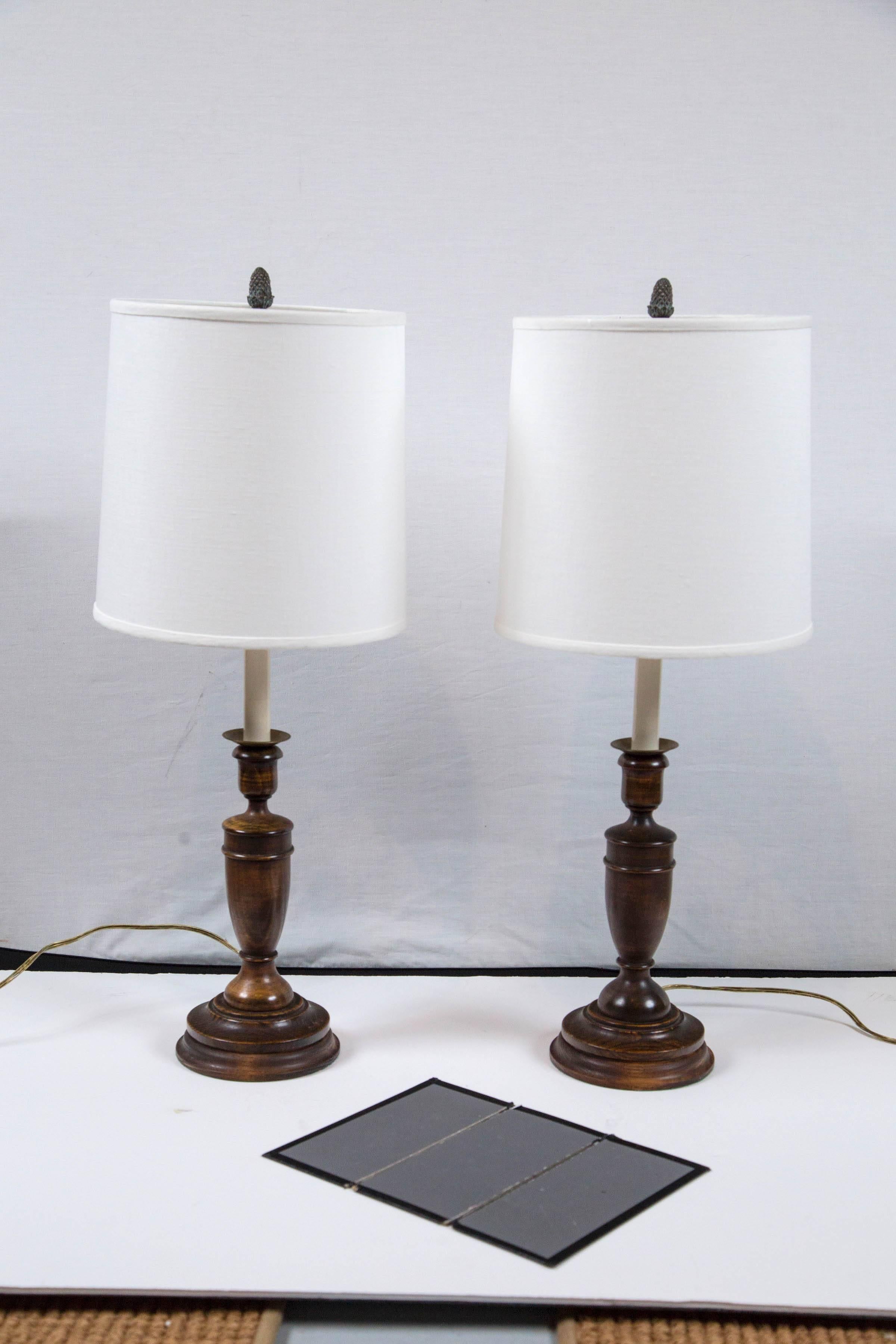 Pair of elmwood candlestick lamps, England, circa 1920. Rewired with new linen shades. Beautifully turned wood with rich patina.