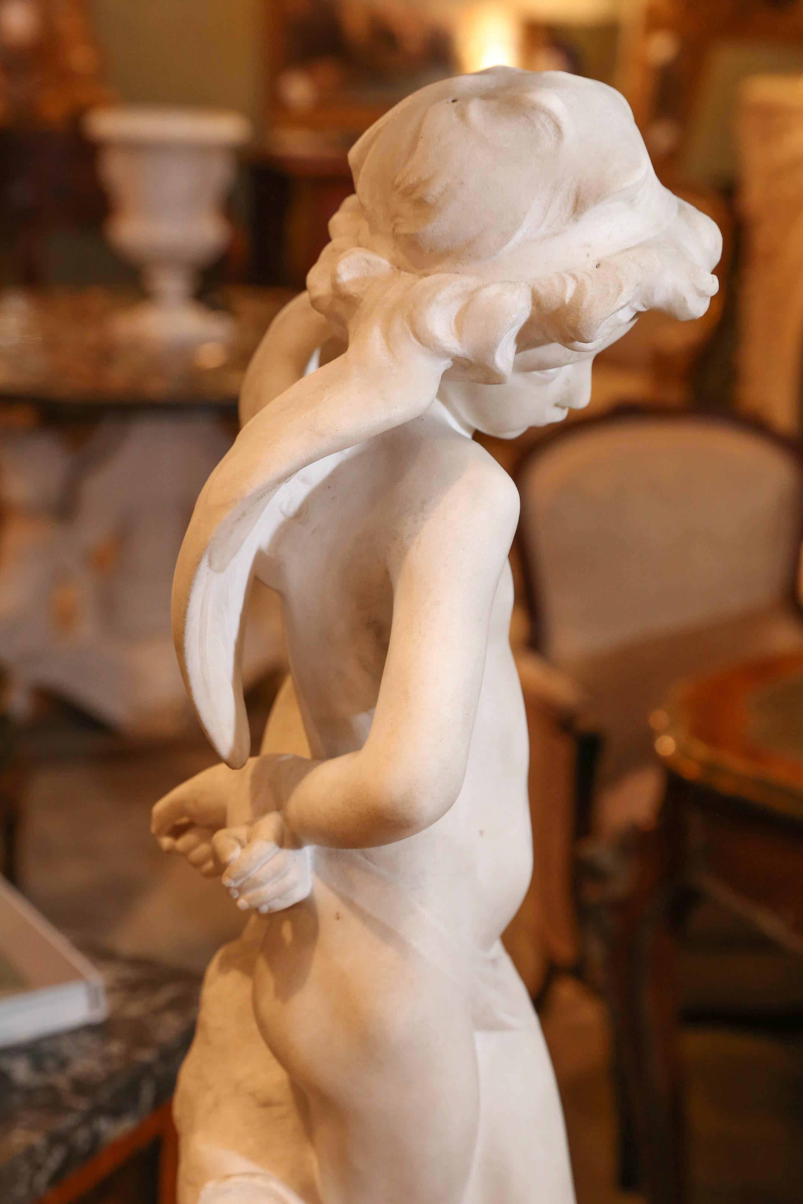 A lovely Carrara marble sculpture of a demure Cupid. Standing by
a tree trunk with his quiver at his side.