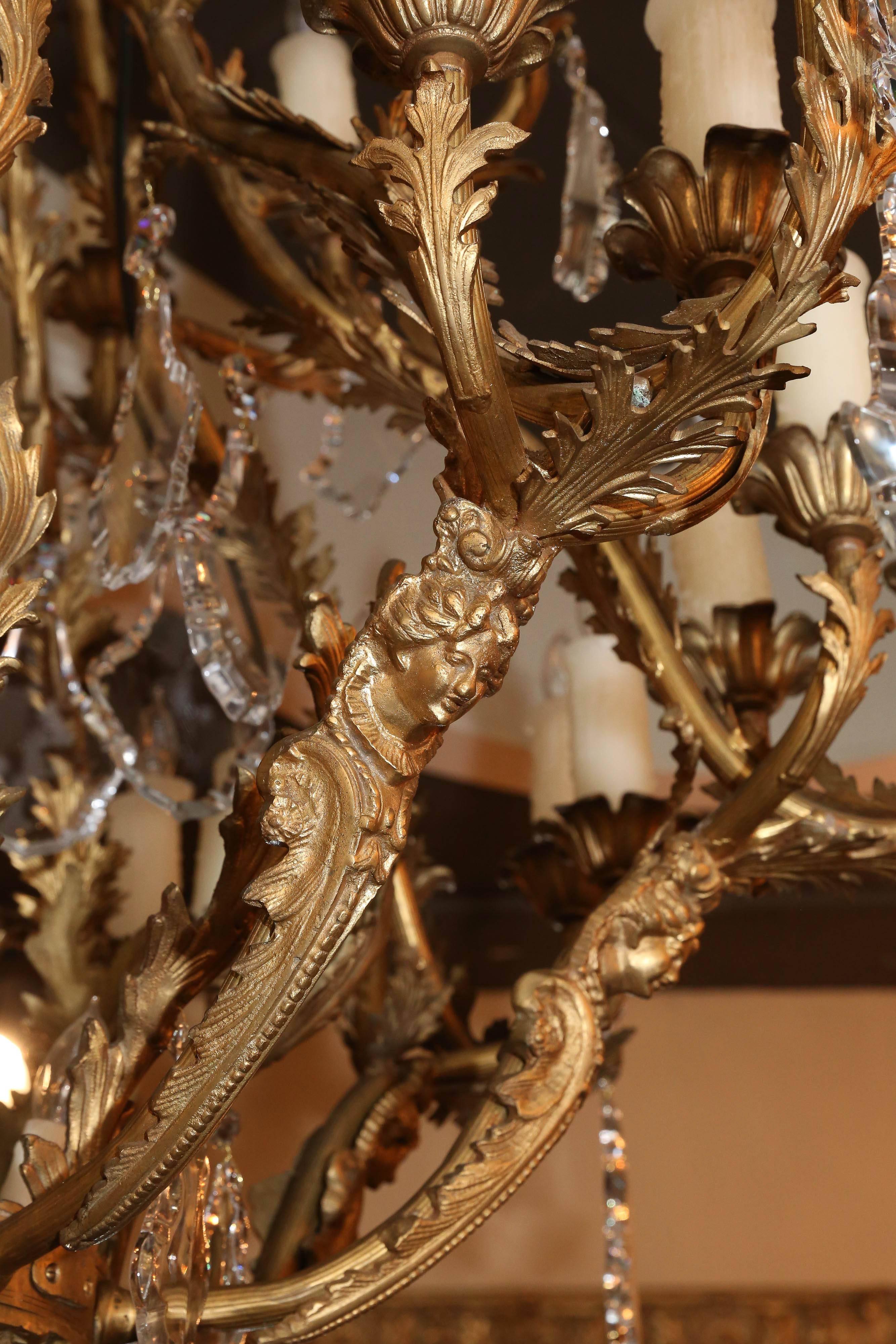 Exquisite bronze chandelier in antique finish with large crystals
a beautiful female head adorns eight branches which holds
three candles on the lower circle of this piece. Eight candles
are on the upper circle. At the pediment of this piece