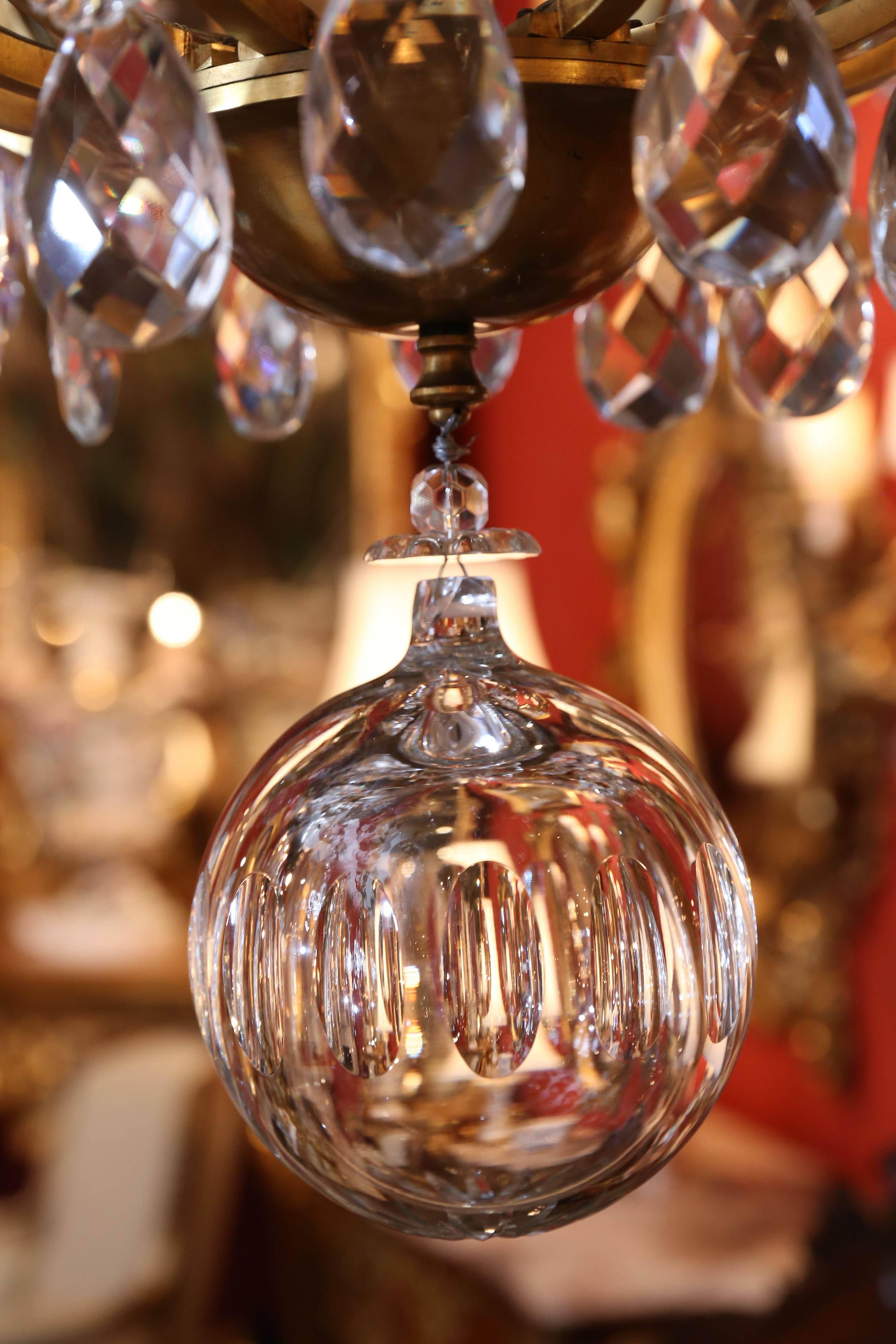 Beautiful and large twenty-light chandelier; gilt cage with central shaped glass
Stem issuing serpentine scrolled arms, cut crystal pendants and finials
Throughout, ending in crystal globe drop.