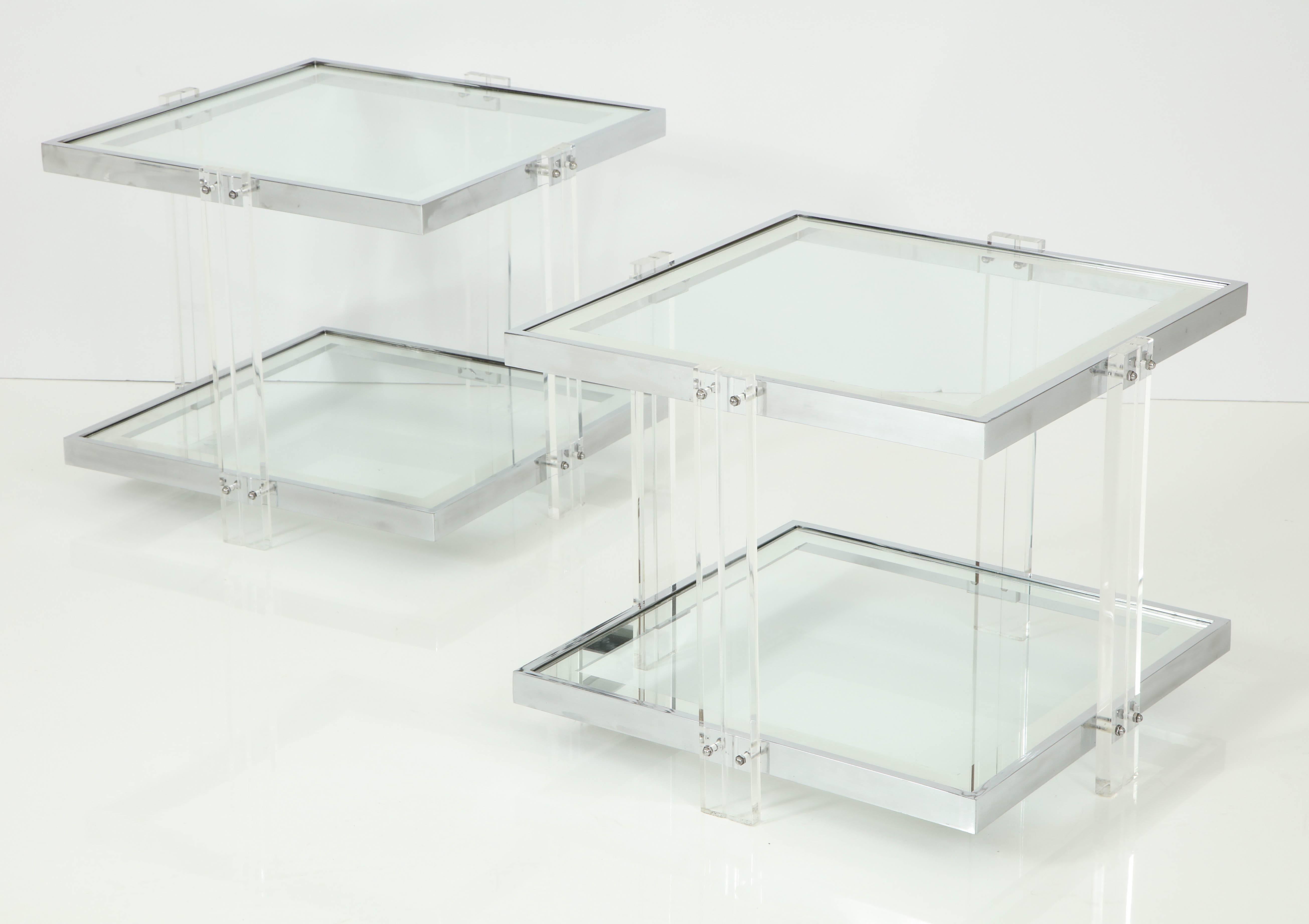 Pair of decorative side tables, circa 1950. Designed in Lucite with polished chrome details. Glass shelves have 1.5