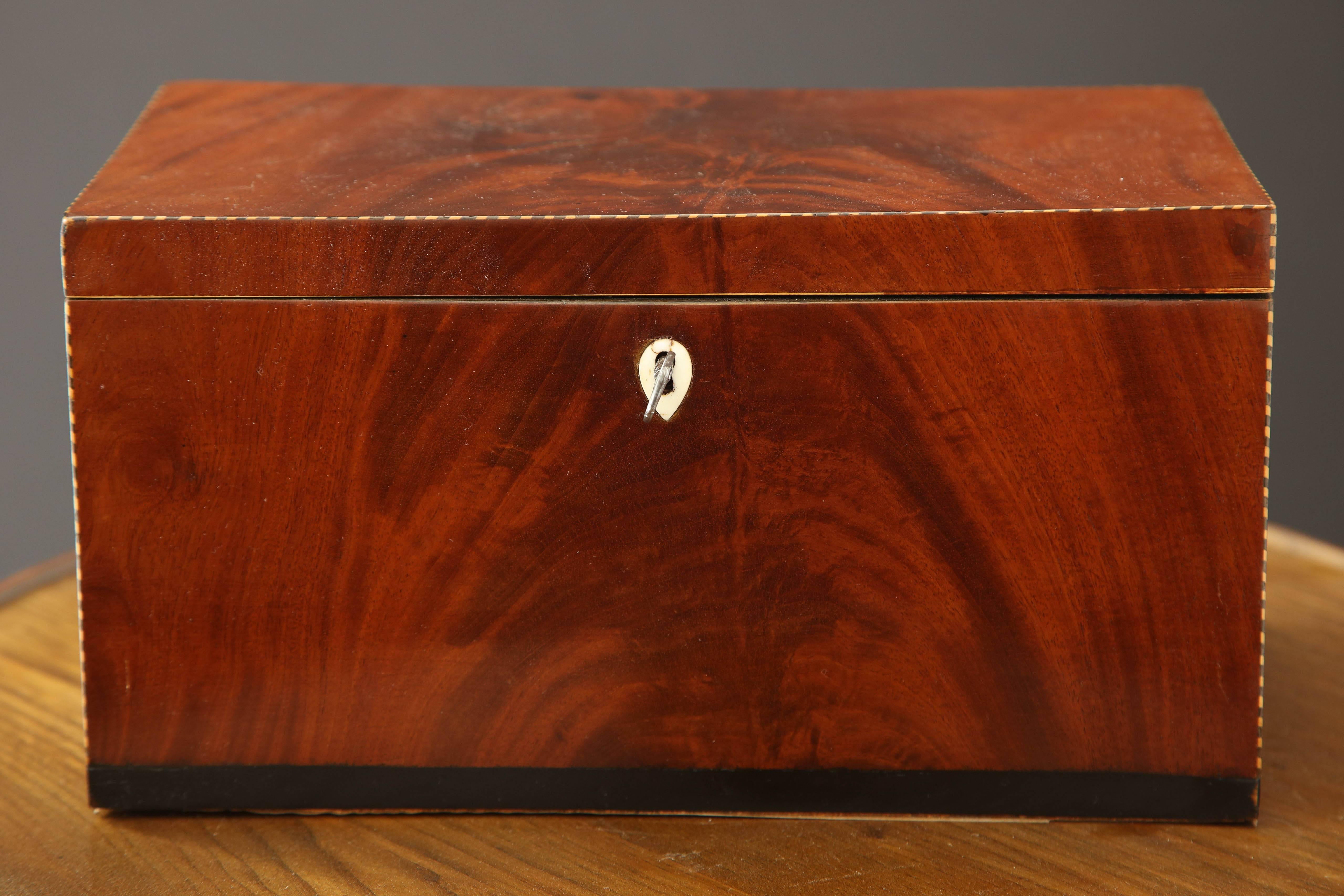 A Danish Empire mahogany and fruitwood inlaid box with a fitted and mirrored interior, early 19th century.
