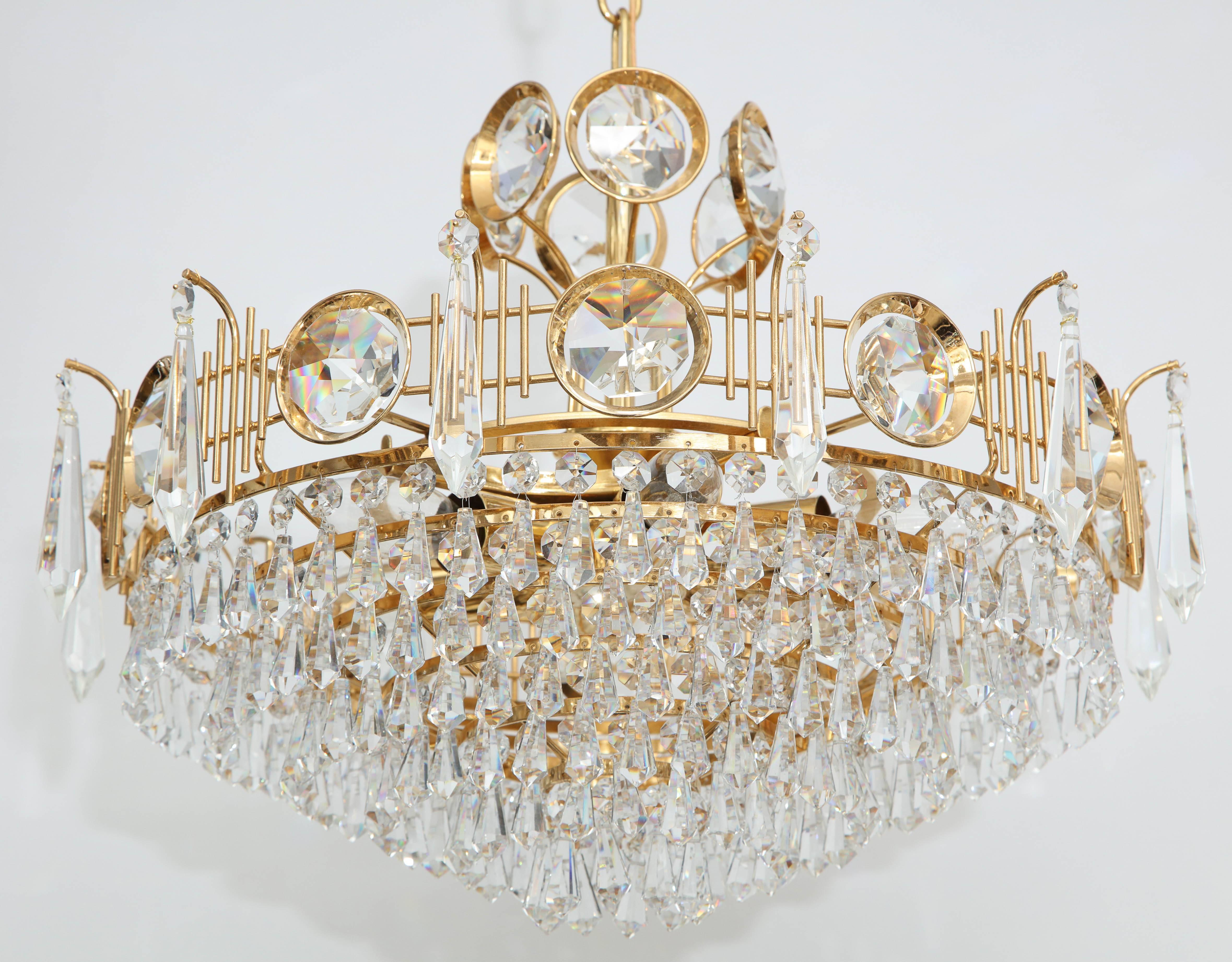 Stunning multi tiered crystal tear drop chandelier with faceted crystal discs on a 22-Karat gold plated frame. Rewired for use in the USA. Gold plated brass frame houses eight sockets which use candelabra type bulbs. Chandelier body is 12.25 inches