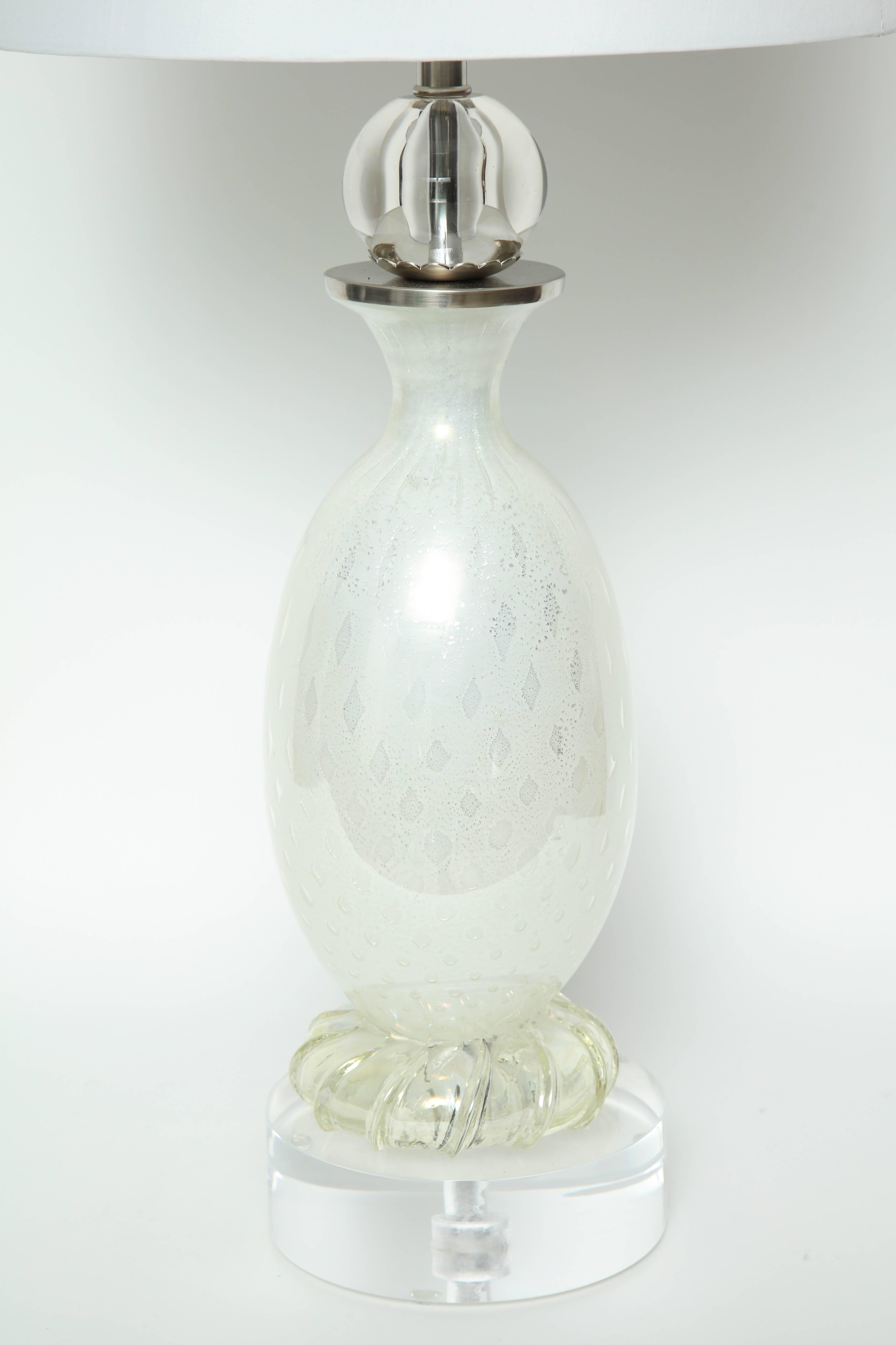 Mid-Century Murano glass lamps in a pearl white color with silver flecking throughout. Lamps feature a subtle dot pattern composed of silver flecking and a solid glass sphere element at top. Lamps have been rewired for use in the USA and have been