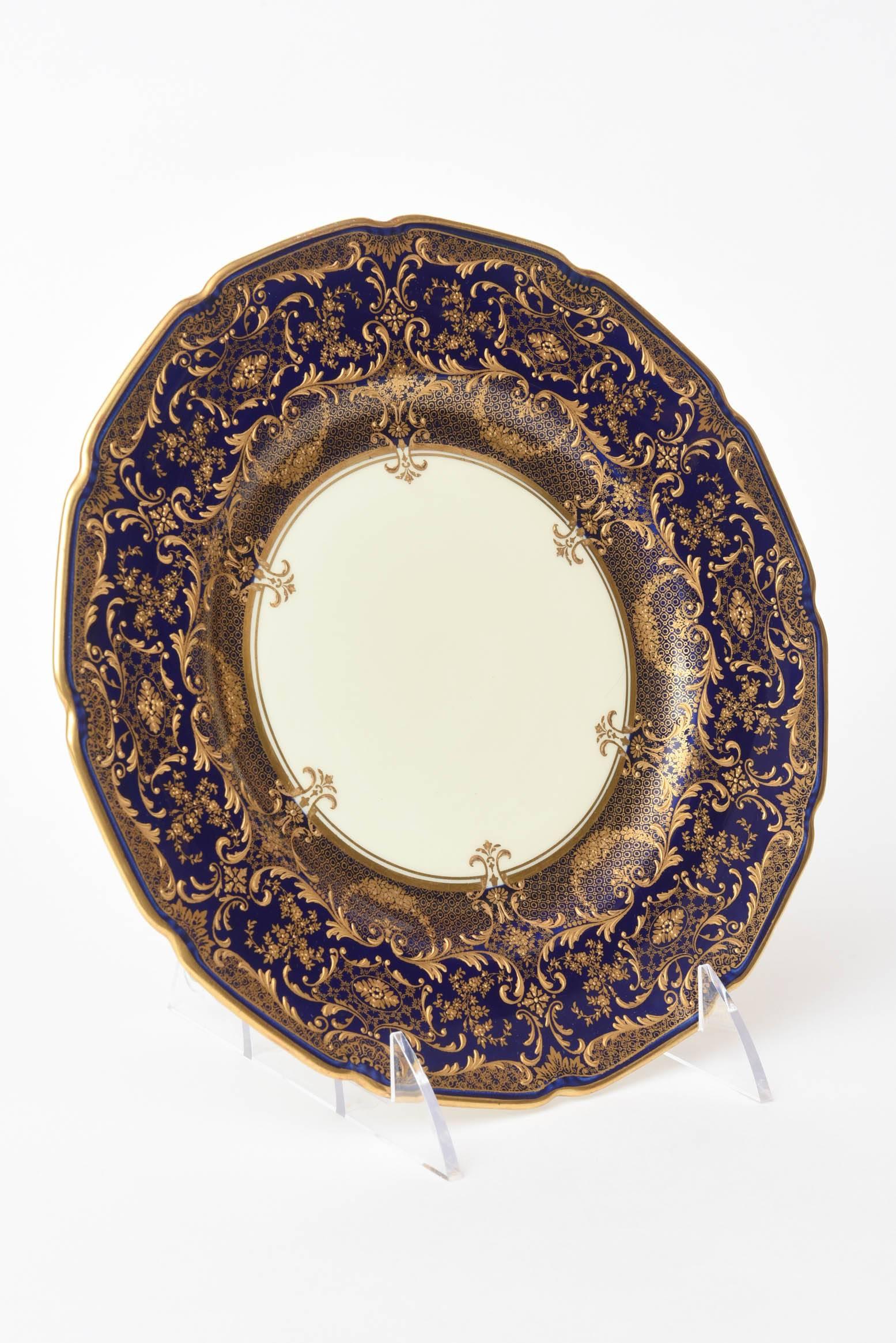 An impressive and highly decorated set of antique plates featuring lots of raised tooled gilding on a Classic Robert Allen shaped plate with crisp vibrant cobalt blue shoulders. Custom ordered through the fine retailers of Ovington Brothers New York