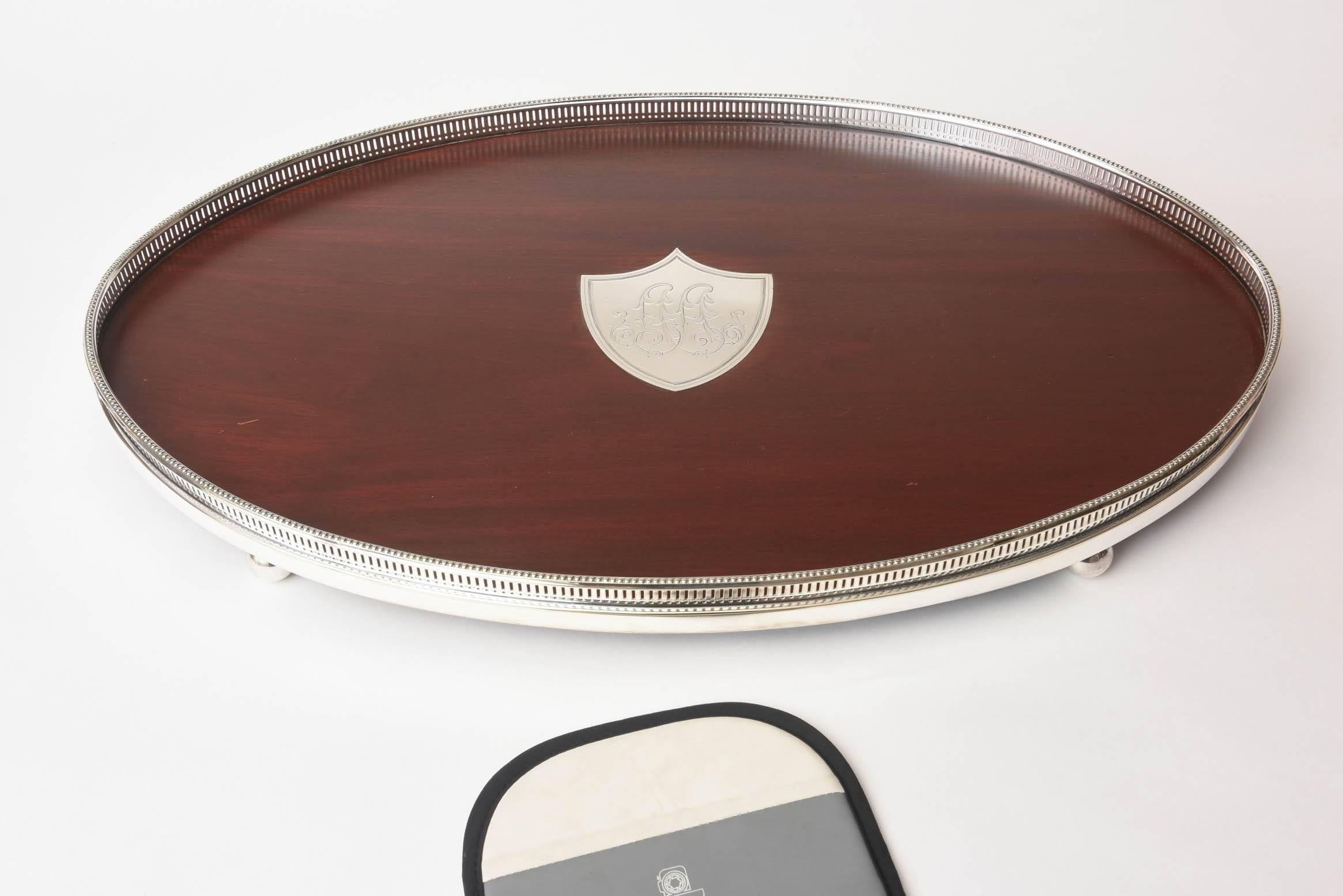 A lovely rosewood and silver plated oval shaped tray with solid sterling silver shield medallion insert. A pierced galley surround and in wonderful vintage condition.