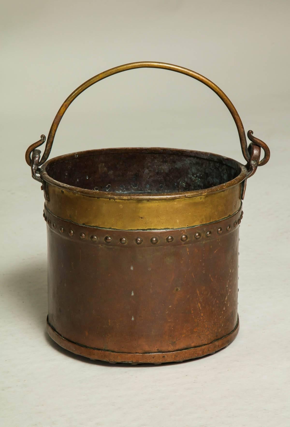 Unusual diminutive copper and brass apple kettle/ bucket having looped brass handle and rim over hammered copper body and having hand riveted seams, indistinctly signed on rim and dated 185-?
Perhaps made for a child or for a special purpose, this