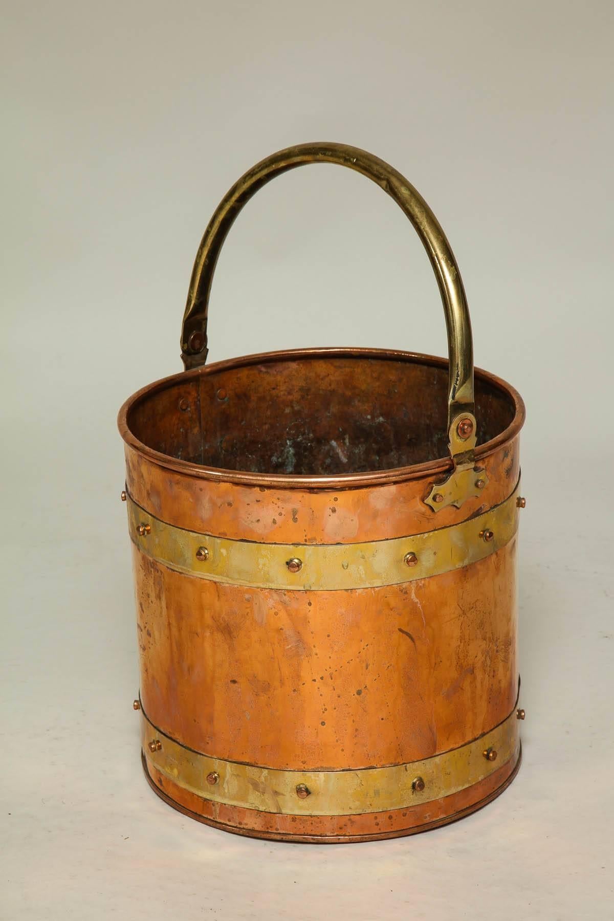 Good early 20th century English copper bucket with brass bands and bail handle with riveted construction and of Good Design. Ideal either for kindling or as waste paper basket.