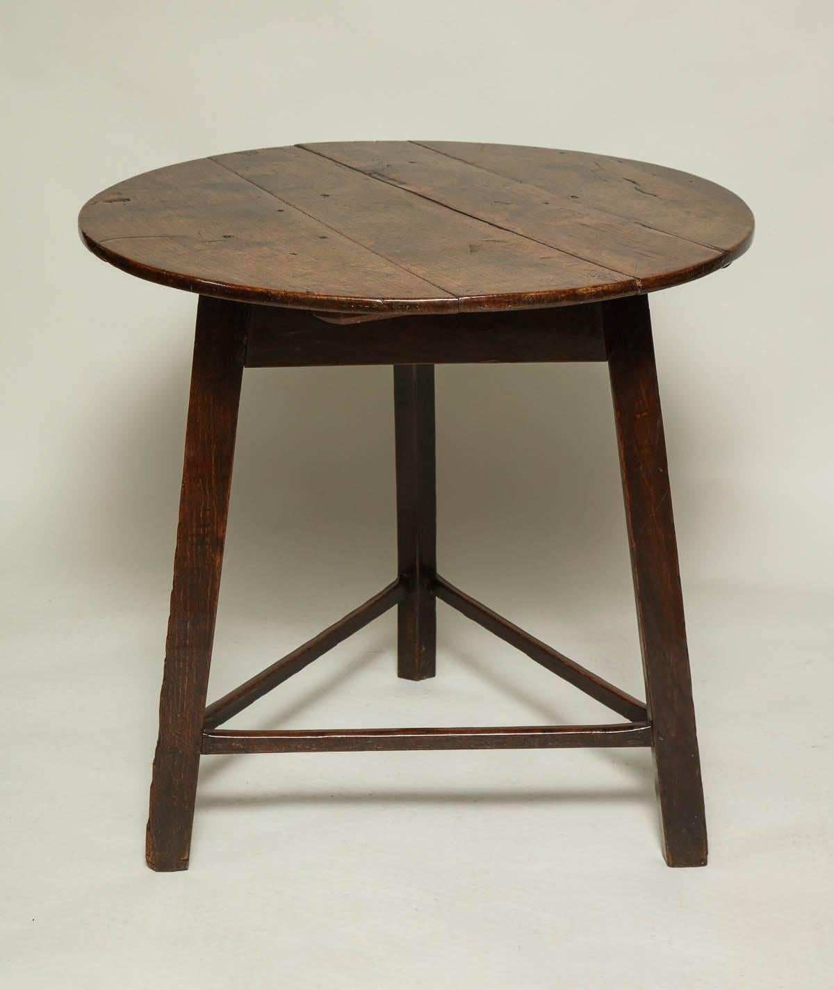 Fine 18th century welsh or English oak cricket table, the vividly grained top with simple rounded edge, over square legs jointed by simple triangle stretcher, the whole possessing good, rich color and patina.