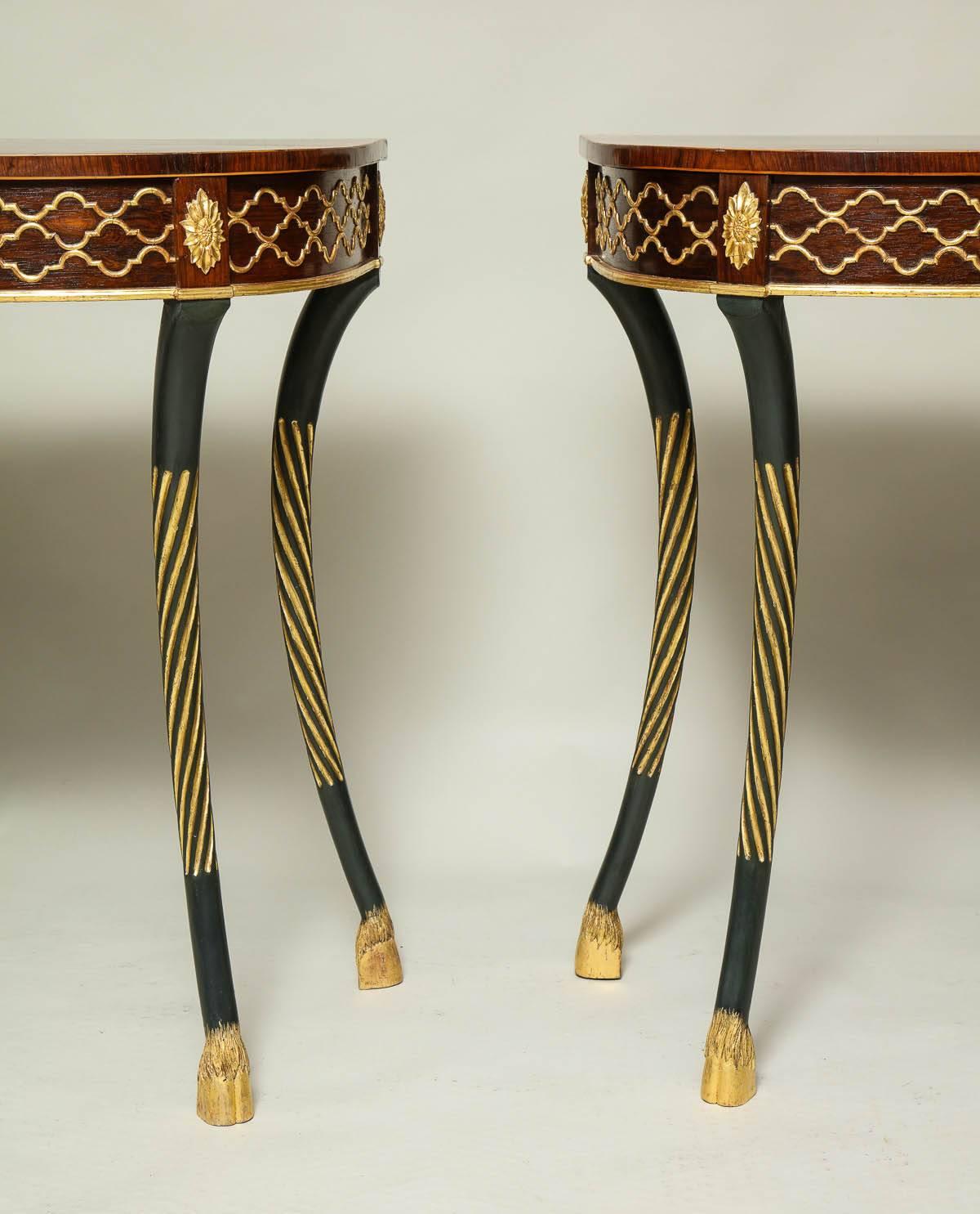 Fine pair of Regency console tables of Gothic design having gilt decoration on a rosewood ground, the rosewood tops with kingwood and satin wood borders, on patinated bronze painted legs with gilt fluting standing on hoof feet.  English, circa 1820.