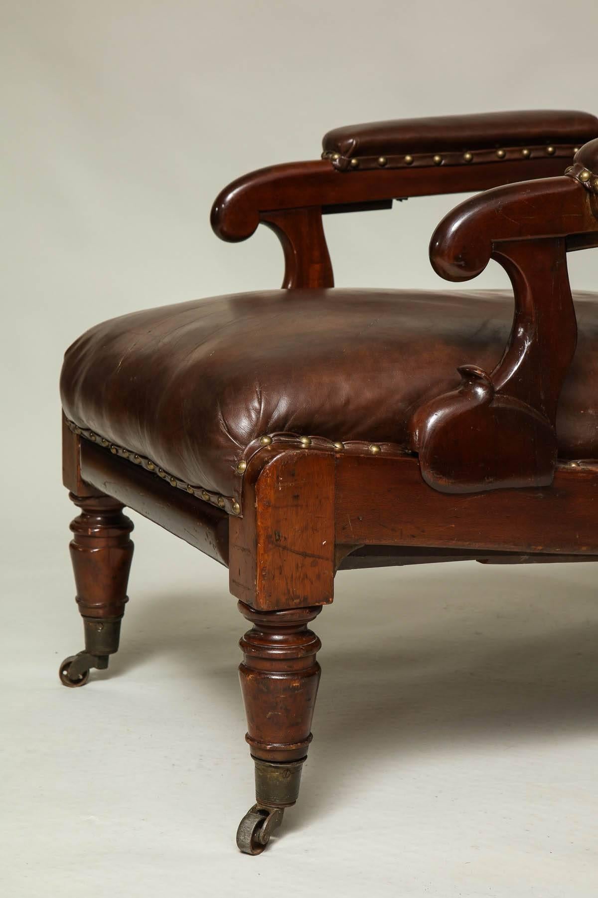 English William IV mahogany library chair with reclining back operated with brass pulls to the underside of the arms, as well as a pullout footrest. A comfortable and handsome chair, England, circa 1835.