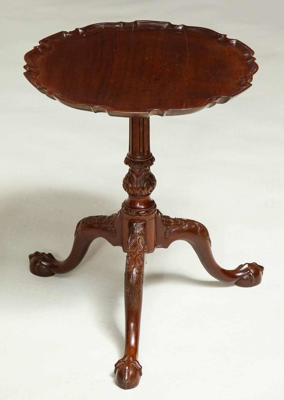 Very fine George II pie crust tripod table, the single board top with scalloped and dished surface, over turned and fluted shaft with acanthus carved stem, the legs with foliage carving over well formed ball and claw feet, exceptionally carved, the