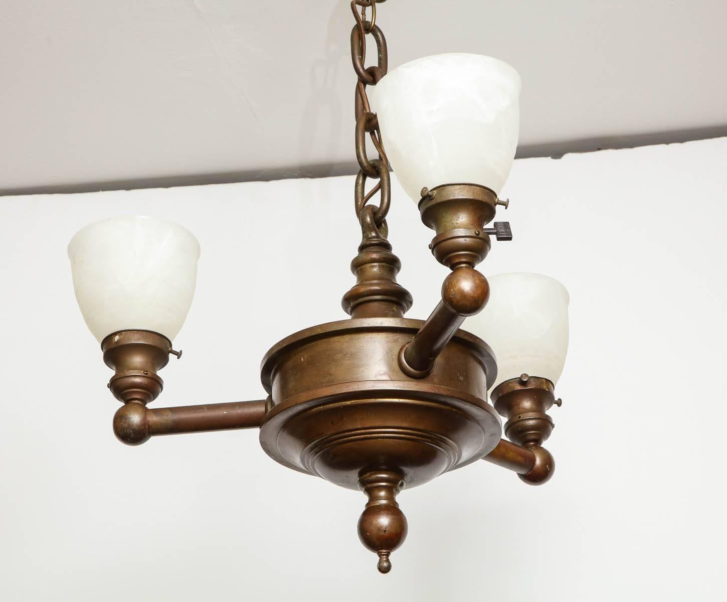 Fine early 20th century patinated bronze three light hanging fixture with frosted shades and strong design.