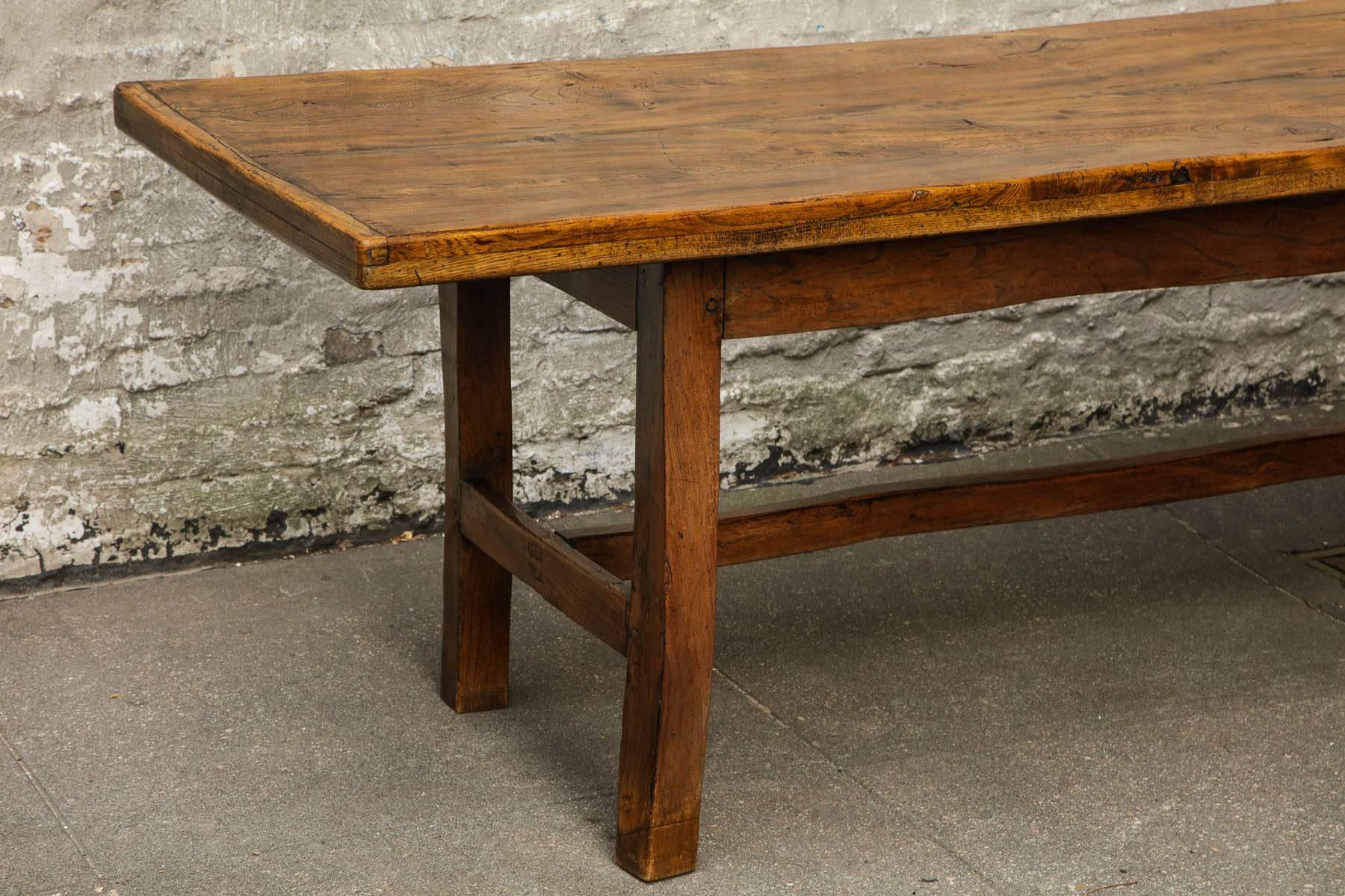An 18th century Welsh farm house table having beautiful rich patina and striking grain.  Thick top of two planks with generous over-hang on square legs joined by long H-stretcher.  Simple, strong architectural lines.