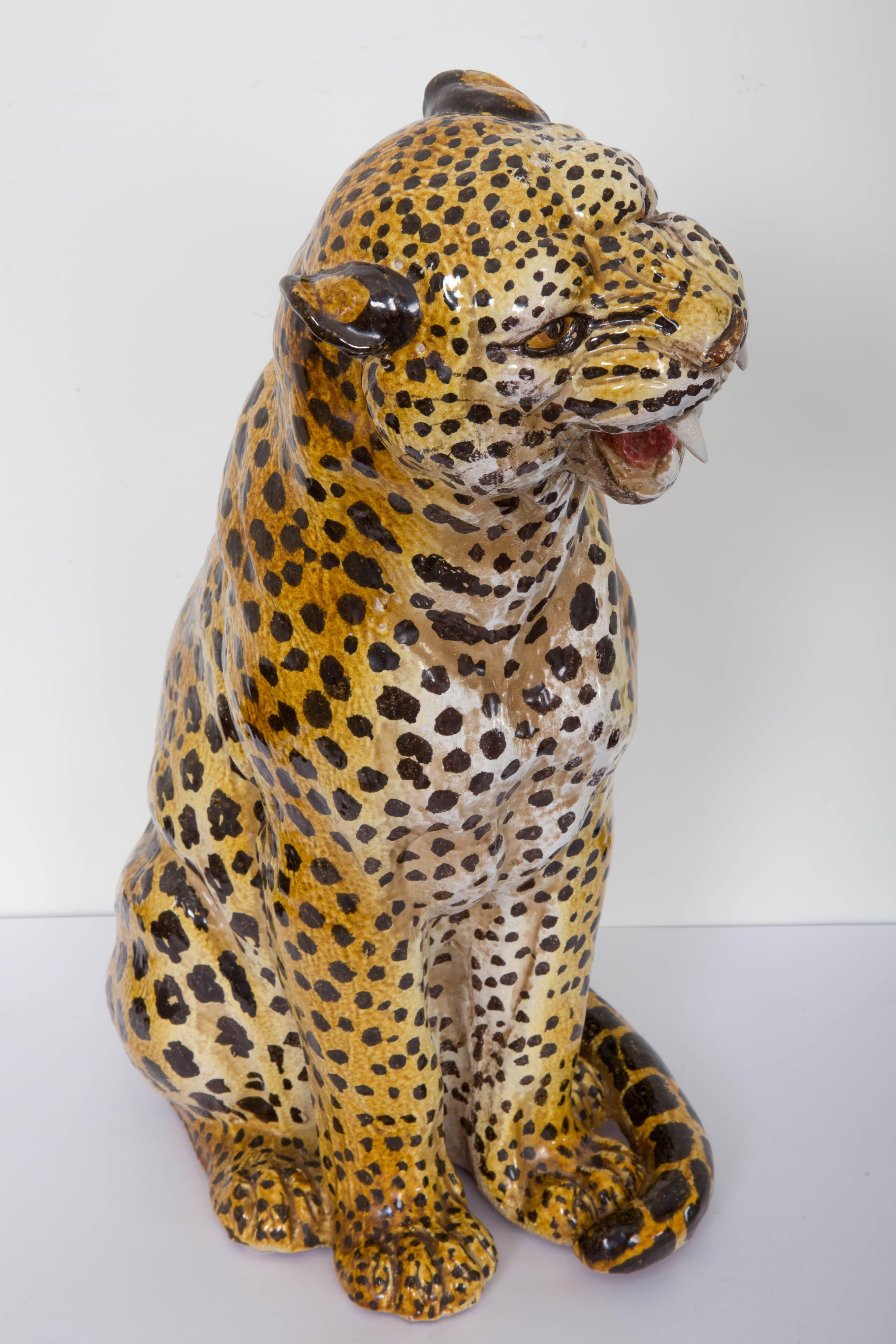 Seated terracotta leopard, regal posture open mouth curled tail.