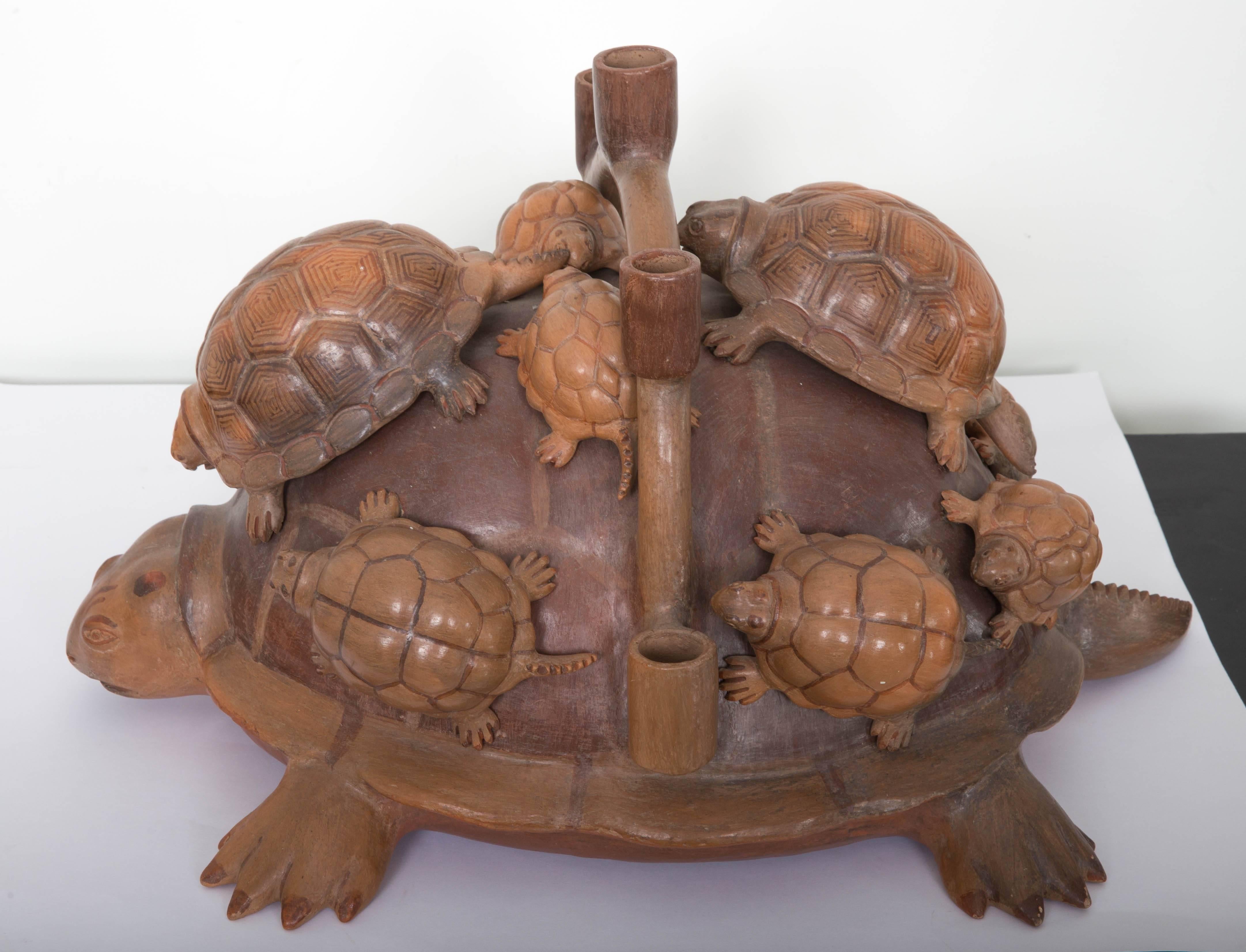 Large ceramic turtle with fie baby on turtle on back. Five candleholders across back. One front toe missing, one toe chipped shown in photos.