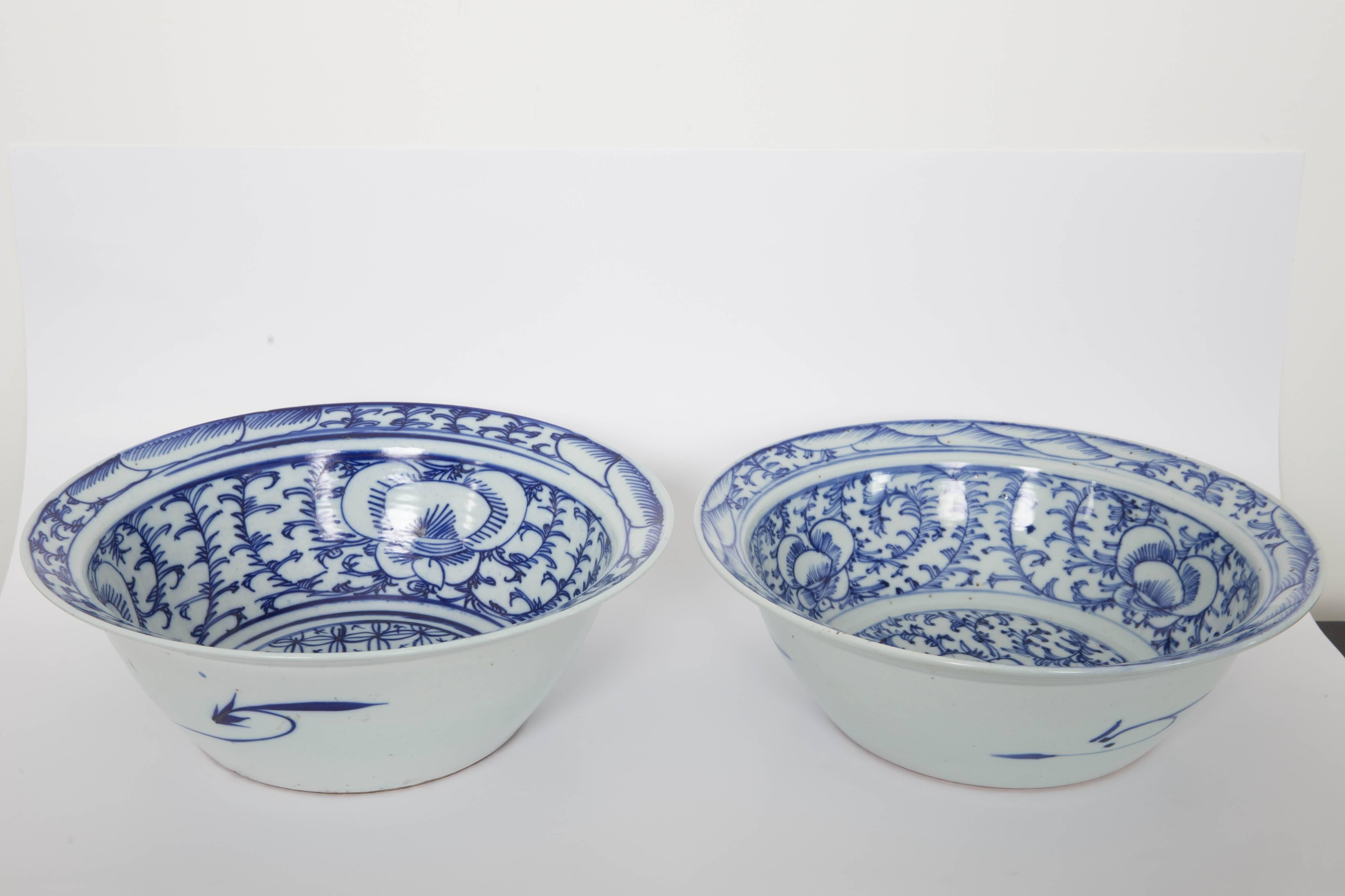 Pair of Chinese blue and white flared rim bowls on handmade wooden stands.